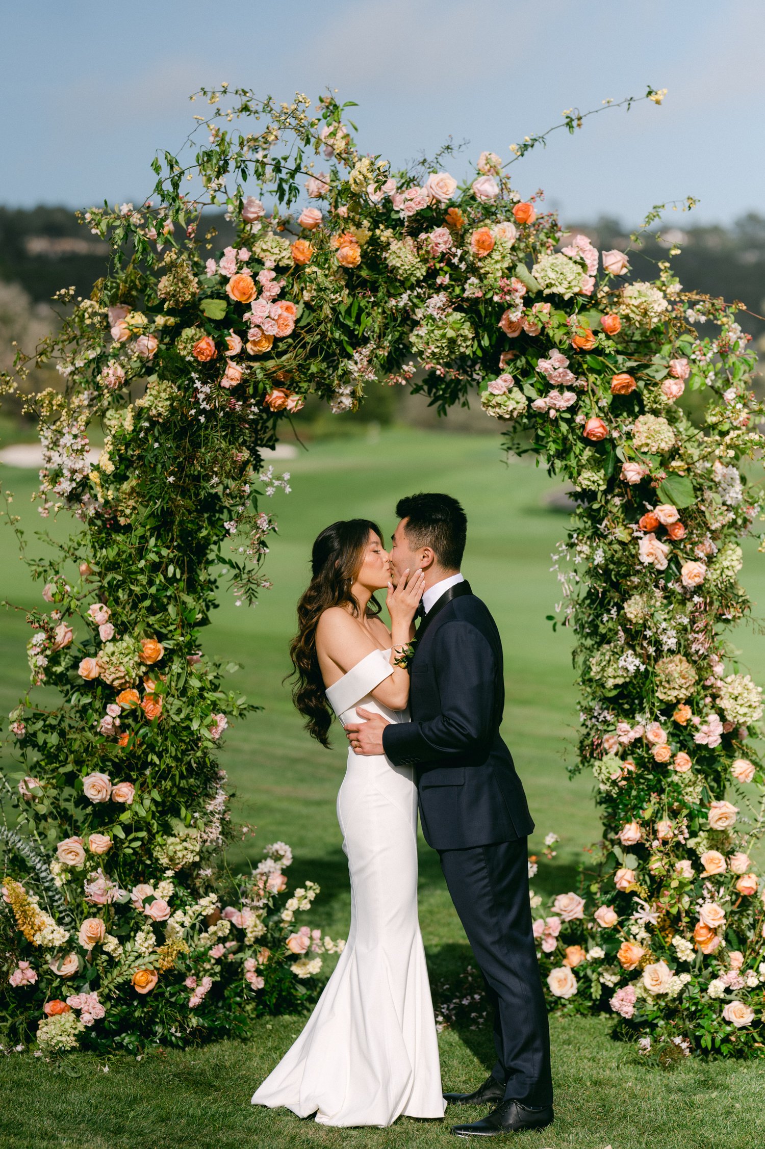 pebble beach resort wedding photo of couple kissing under the arch