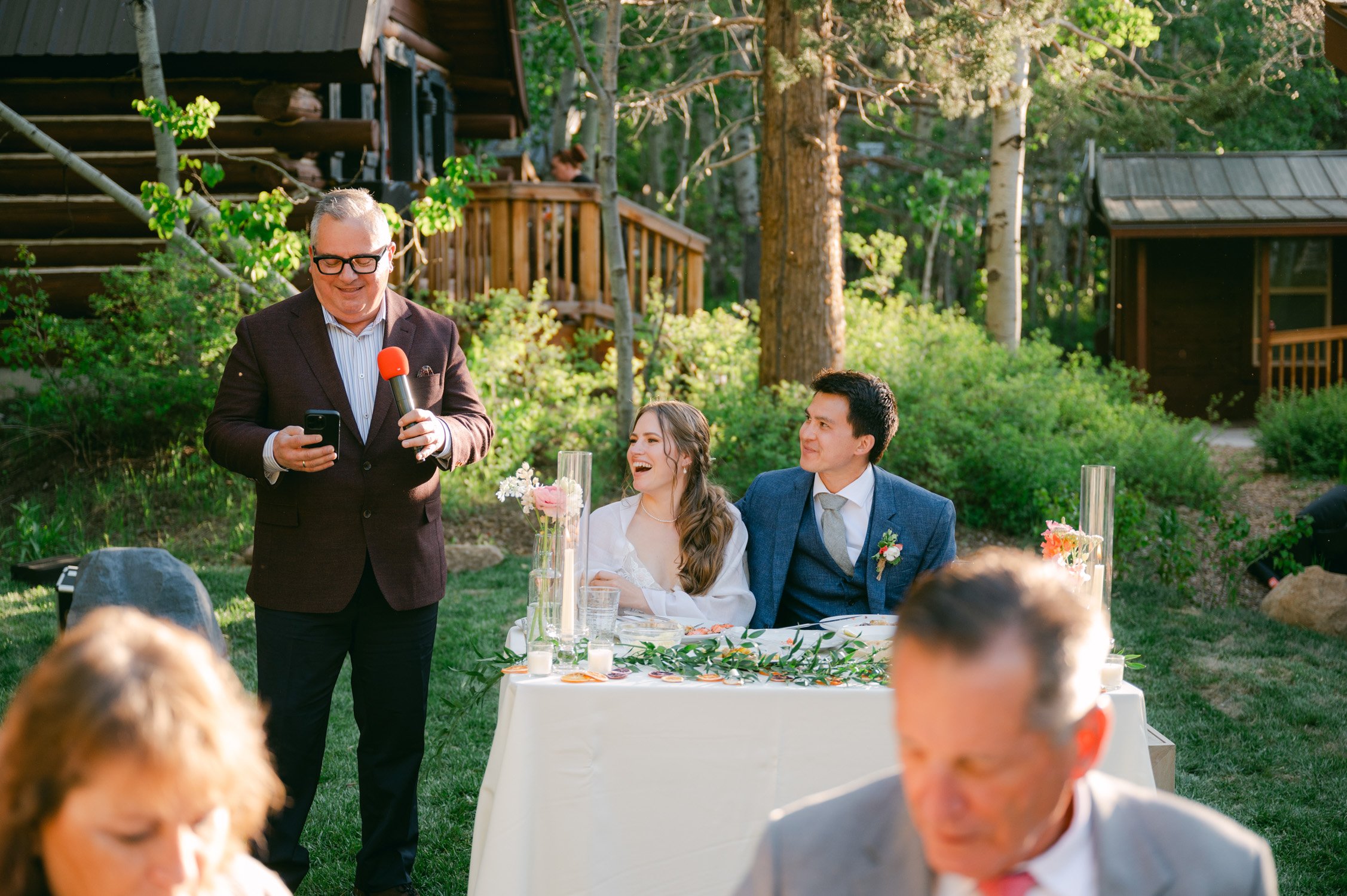 Desolation wilderness hotel wedding, photo of a guest giving a toast to the couple and the couple laughing 