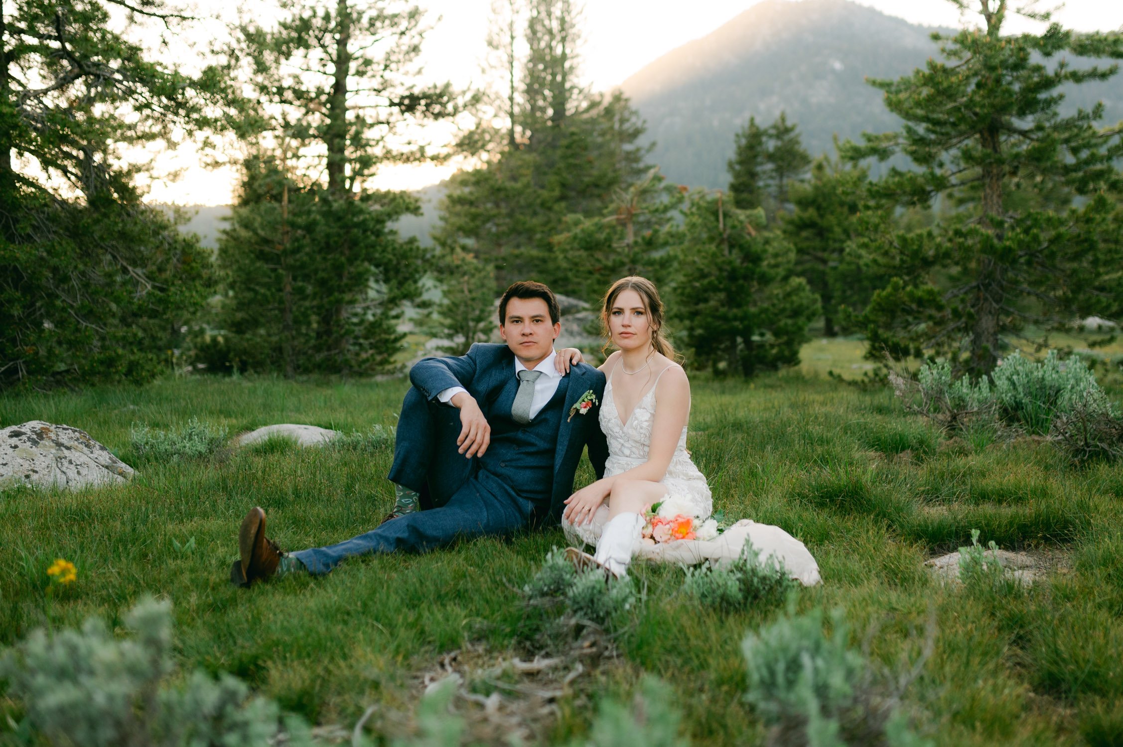 Desolation wilderness hotel wedding, photo of a couple sitting on meadow during sunset