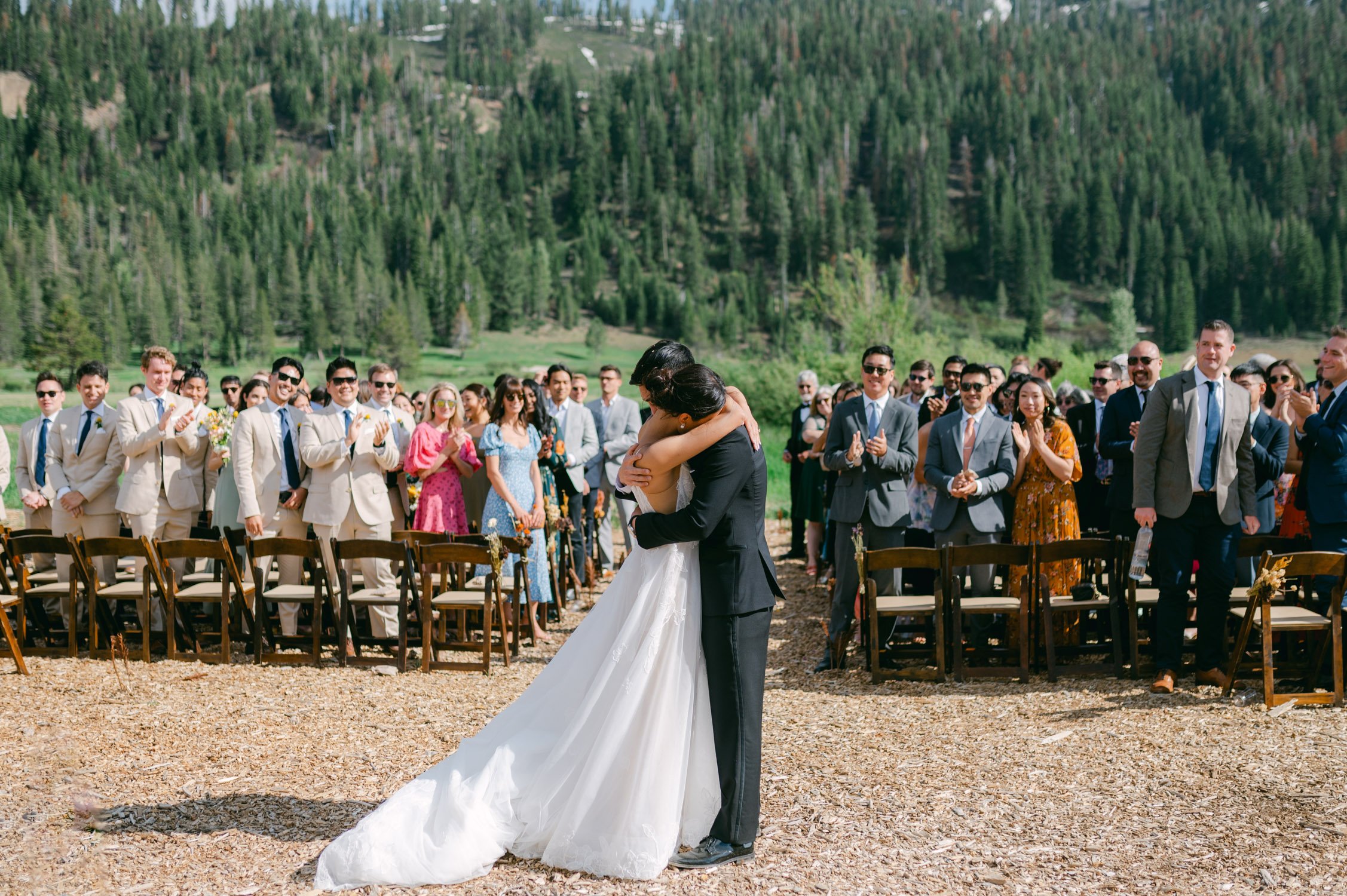 olympic valley stables wedding, photo of the newly wed couple tightly hugging each other in front of their guests 