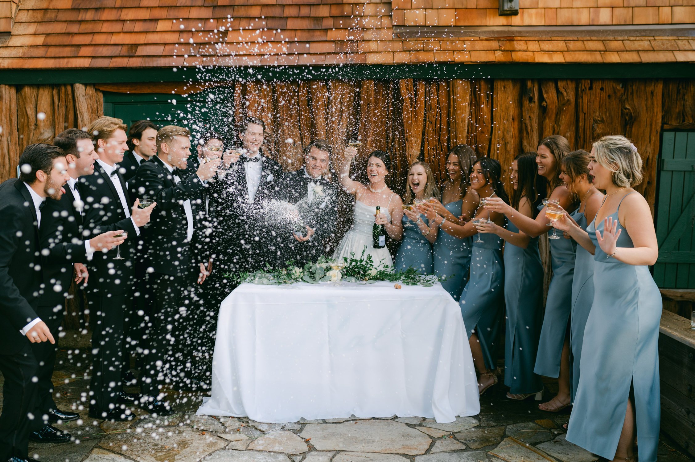 Valhalla Lake Tahoe wedding, photo of the newly wed couple spraying the champagne with their wedding party