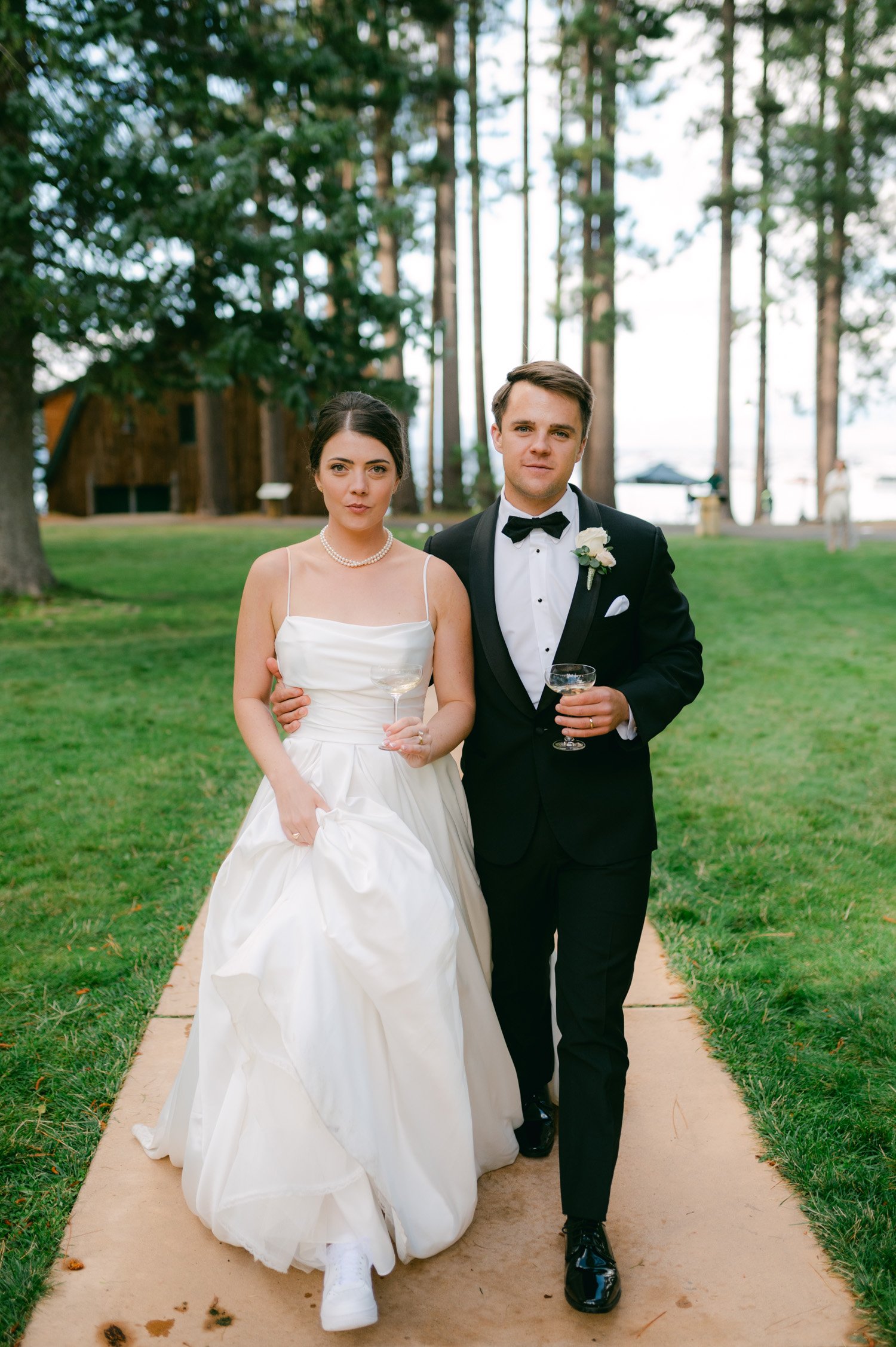 Valhalla Lake Tahoe wedding, photo of the newly wed couple holding a champagne glass walking towards the camera