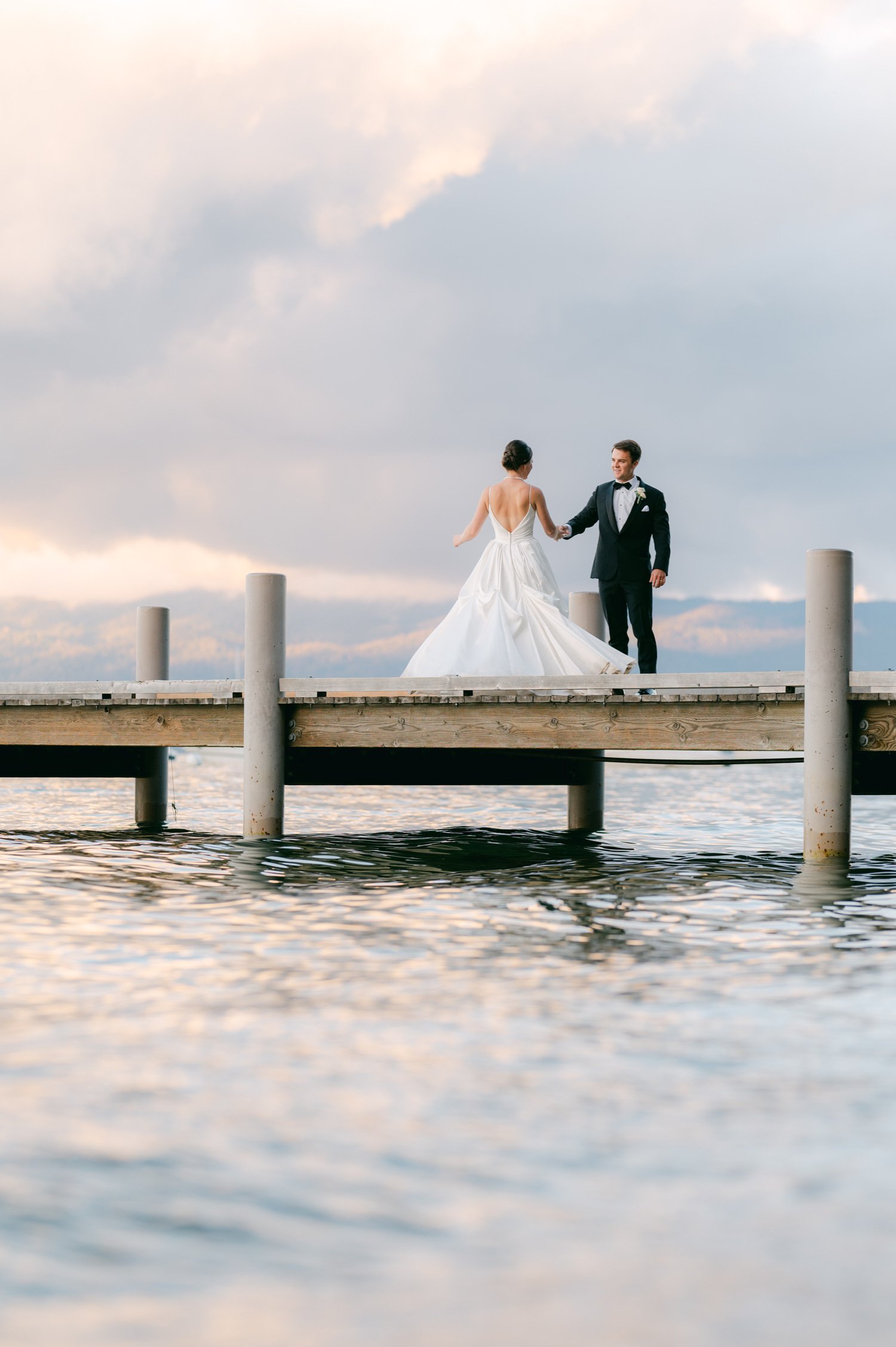 Valhalla Lake Tahoe wedding, photo of the newly wed couple holding hands by the dock