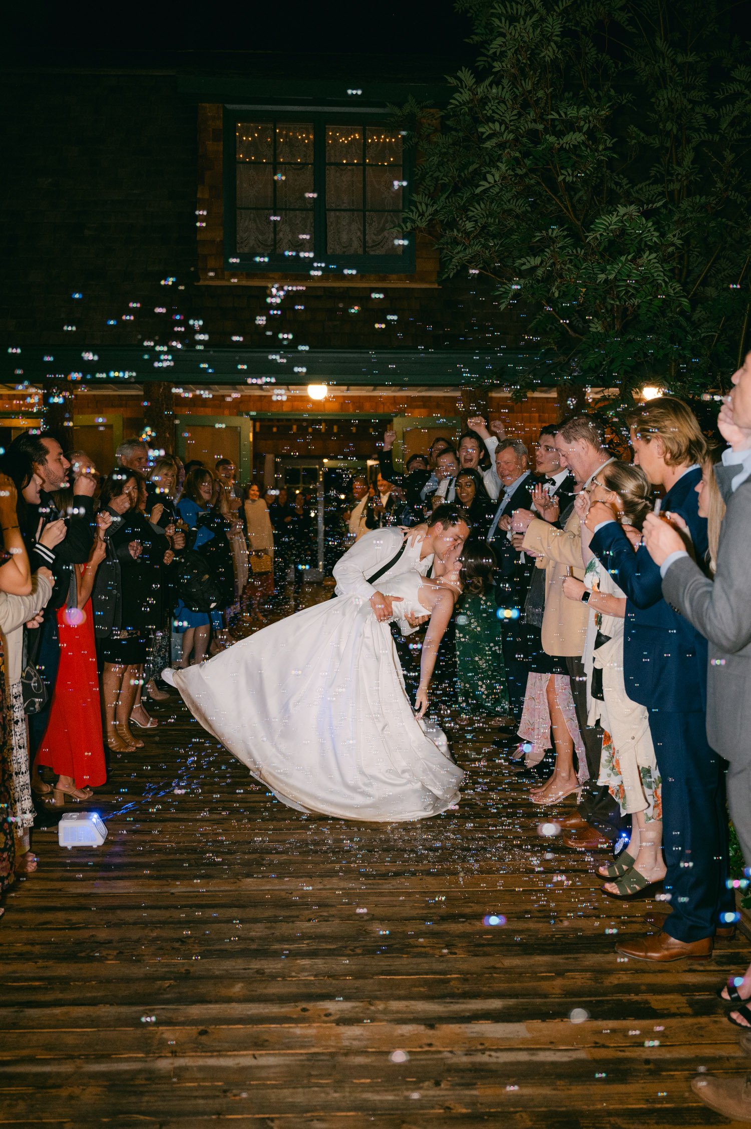 Valhalla Lake Tahoe wedding, photo of the newly wed couple kissing in the middle with bubble shots