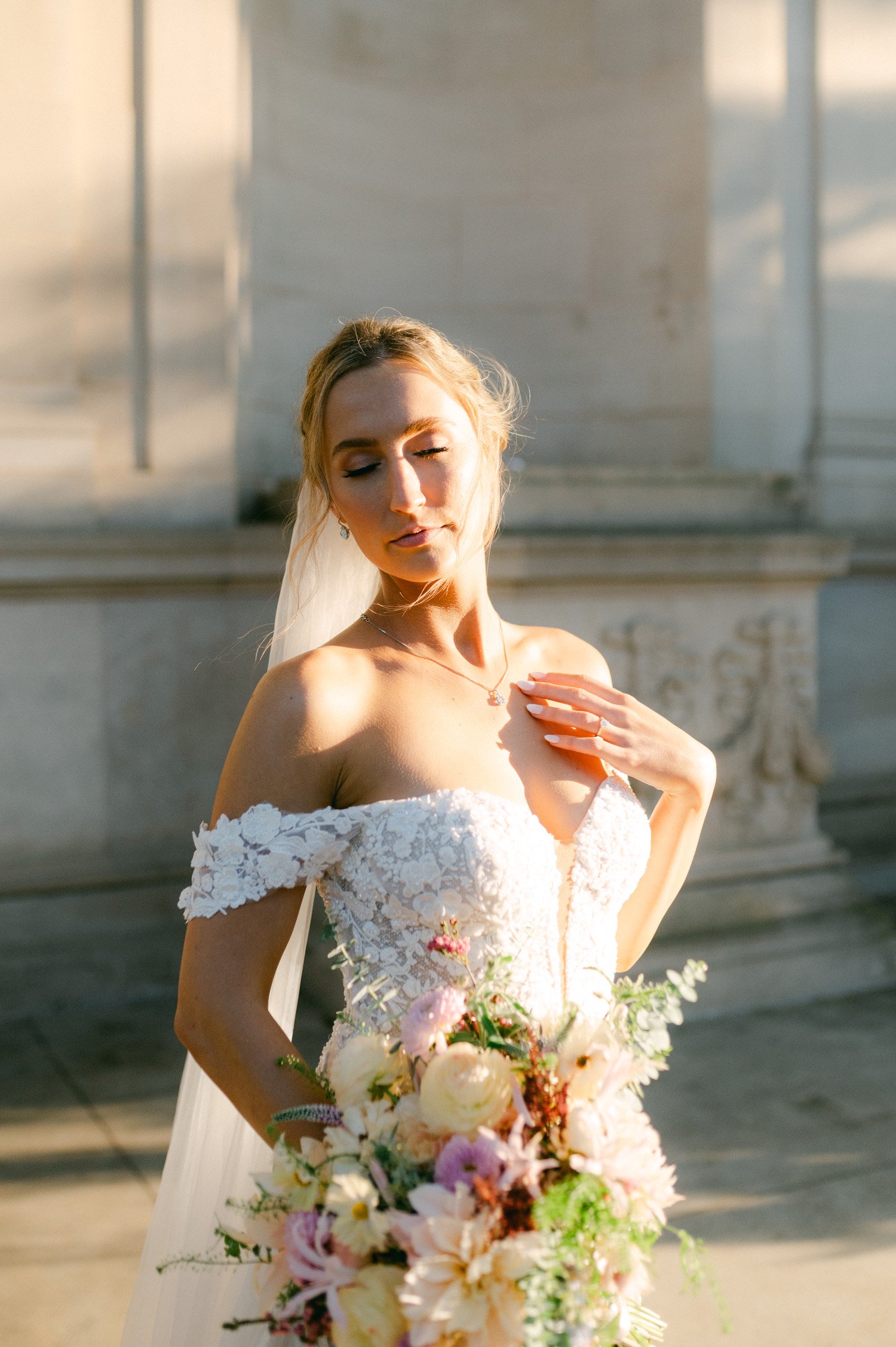 California academy of Sciences in San Francisco Wedding, photo of the bride by the sunlight in her beautiful lace off-shoulder wedding dress and paste colors wedding bouquet