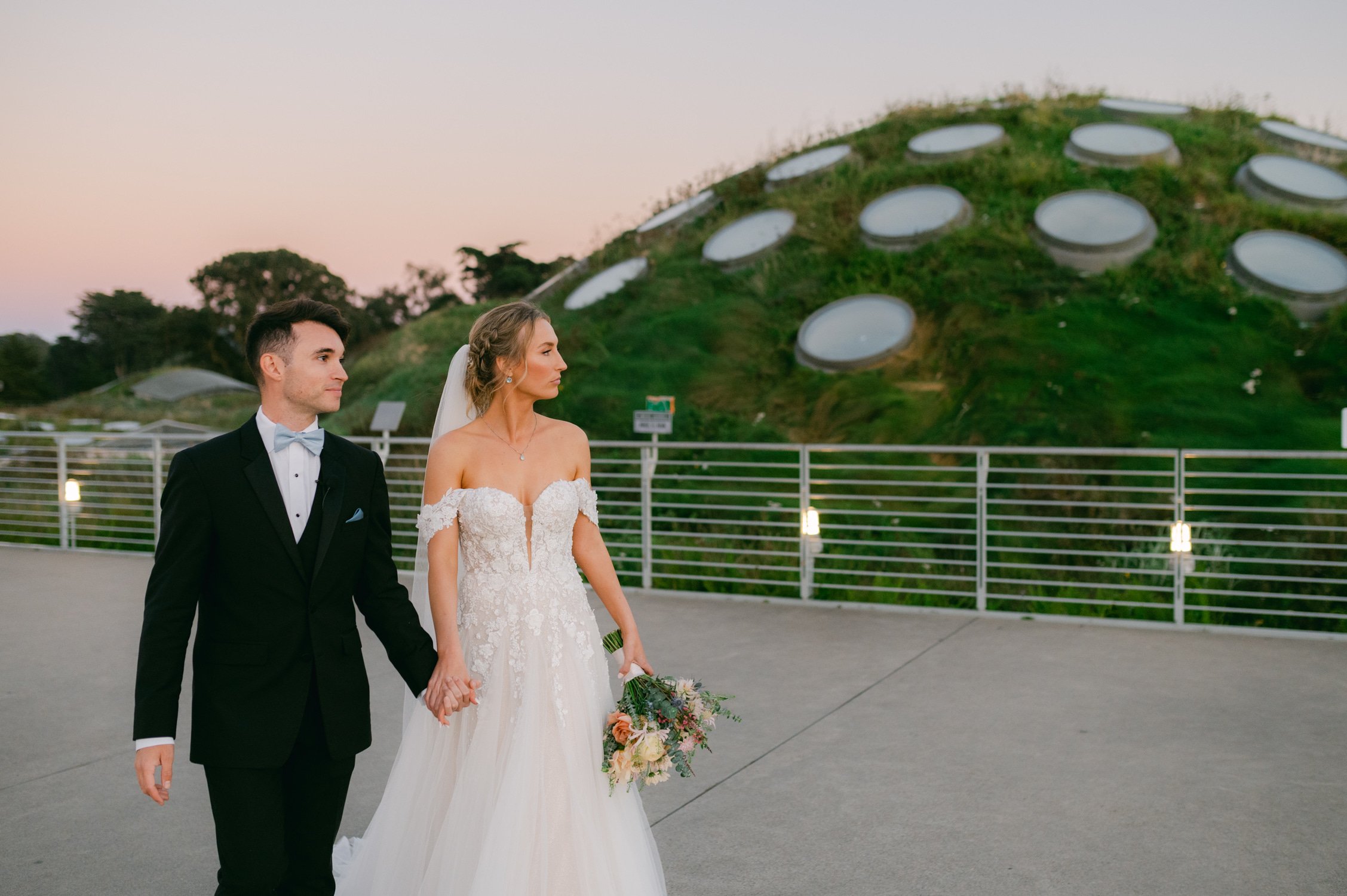California academy of Sciences in San Francisco Wedding, photo of the couple walking outside holding hands