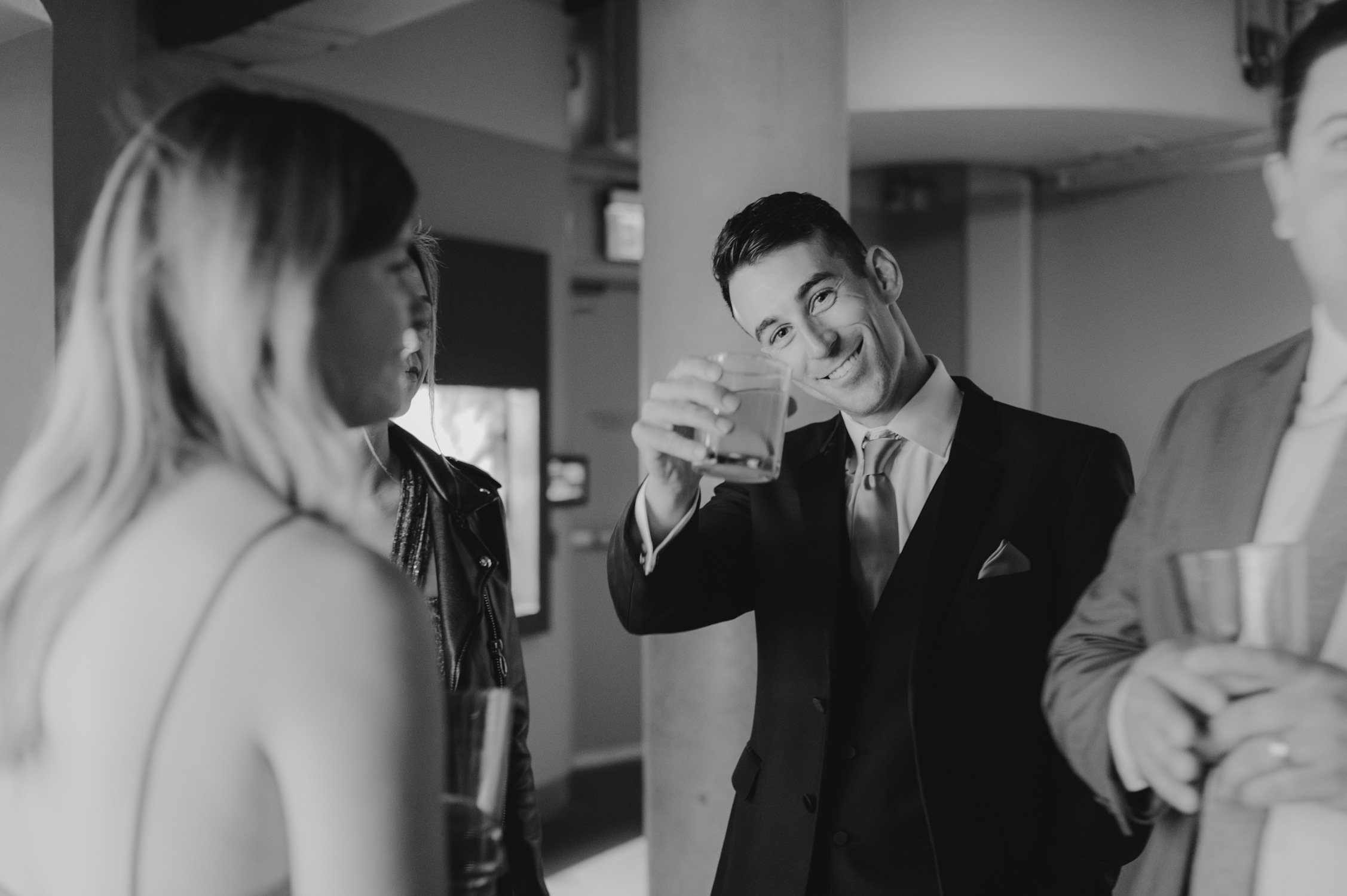 California academy of Sciences in San Francisco Wedding, photo of the wedding guest doing a toast to the camera during the drinks reception