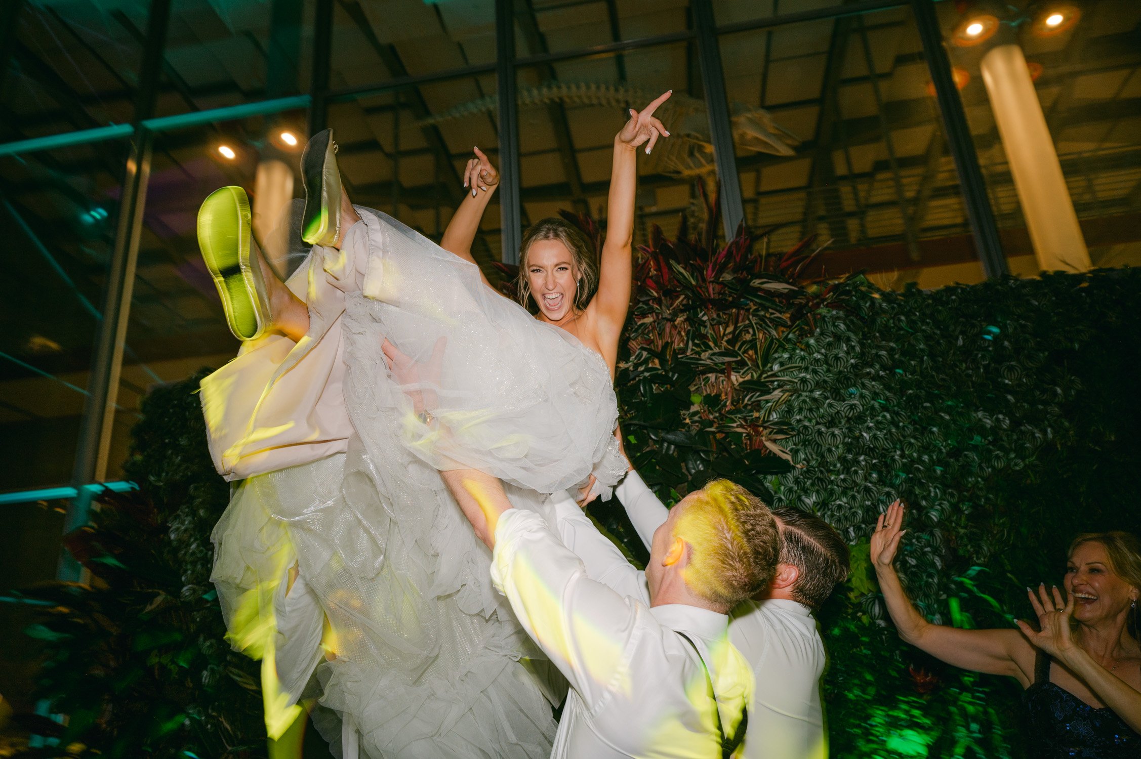 California academy of Sciences in San Francisco Wedding, photo of the bride being carried during the afterparty
