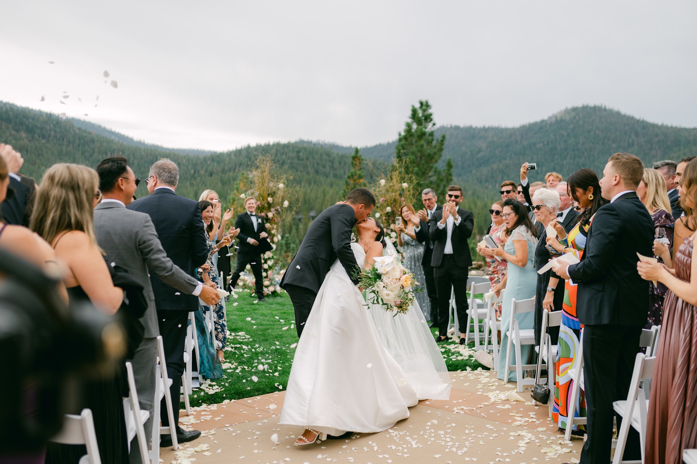 Martis Camp Wedding, photo of the newlywed couple kissing down the aisle as the guest applaud