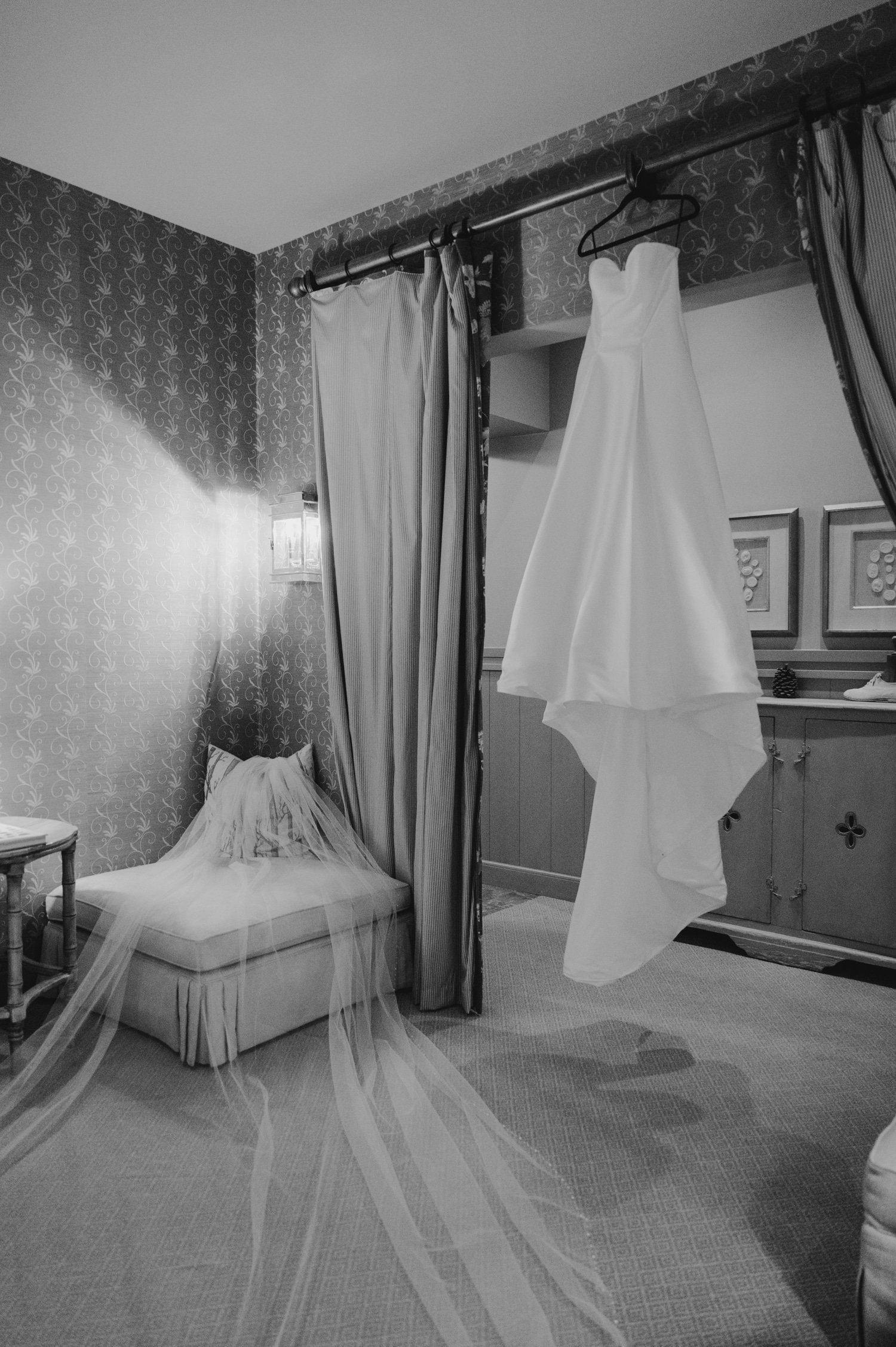 Martis Camp Wedding, photo of the wedding dress hanging and the veil arranged on the couch