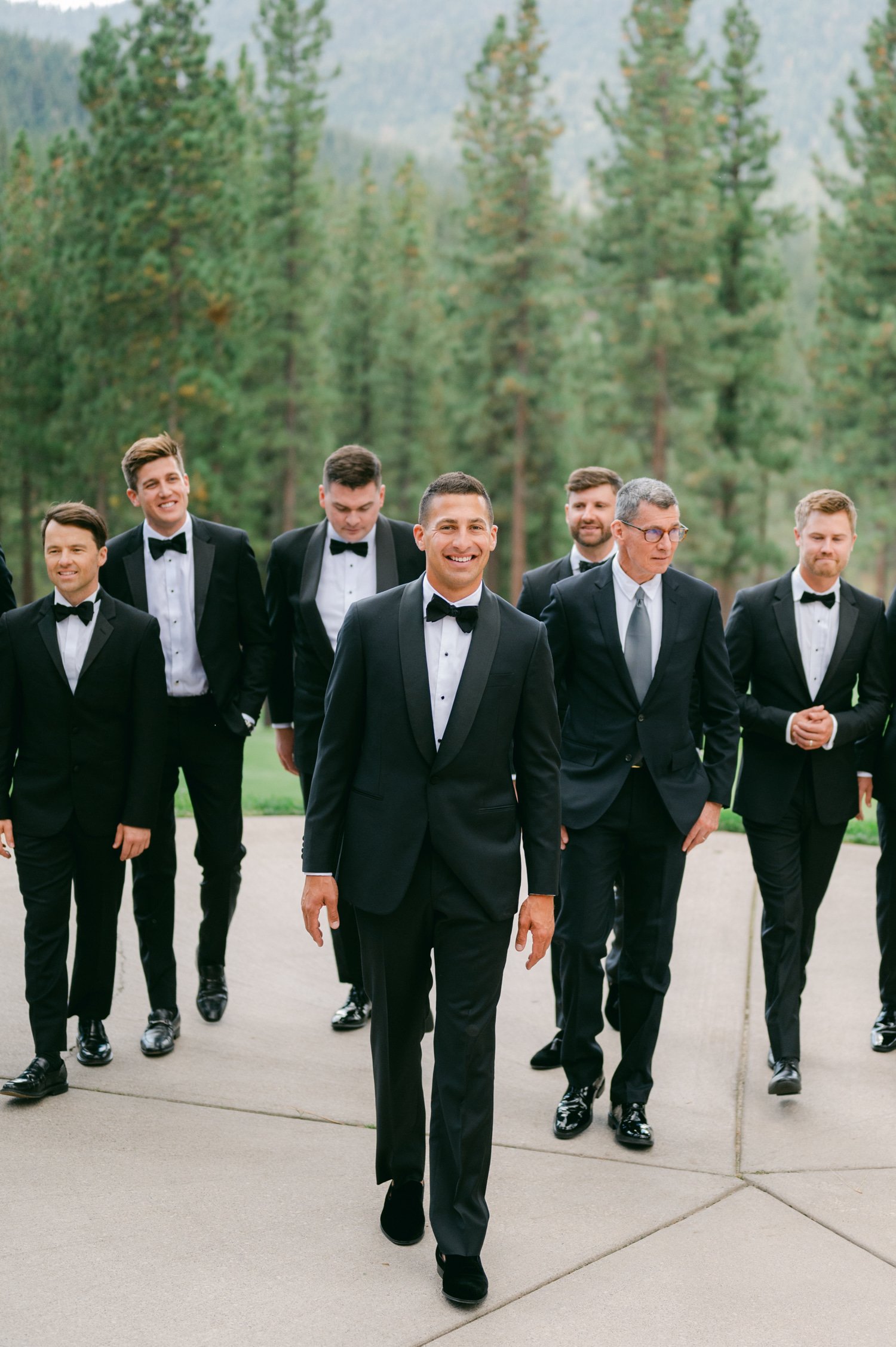 Martis Camp Wedding, photo of the groom and groomsmen walking to the ceremony with tall tress on their background