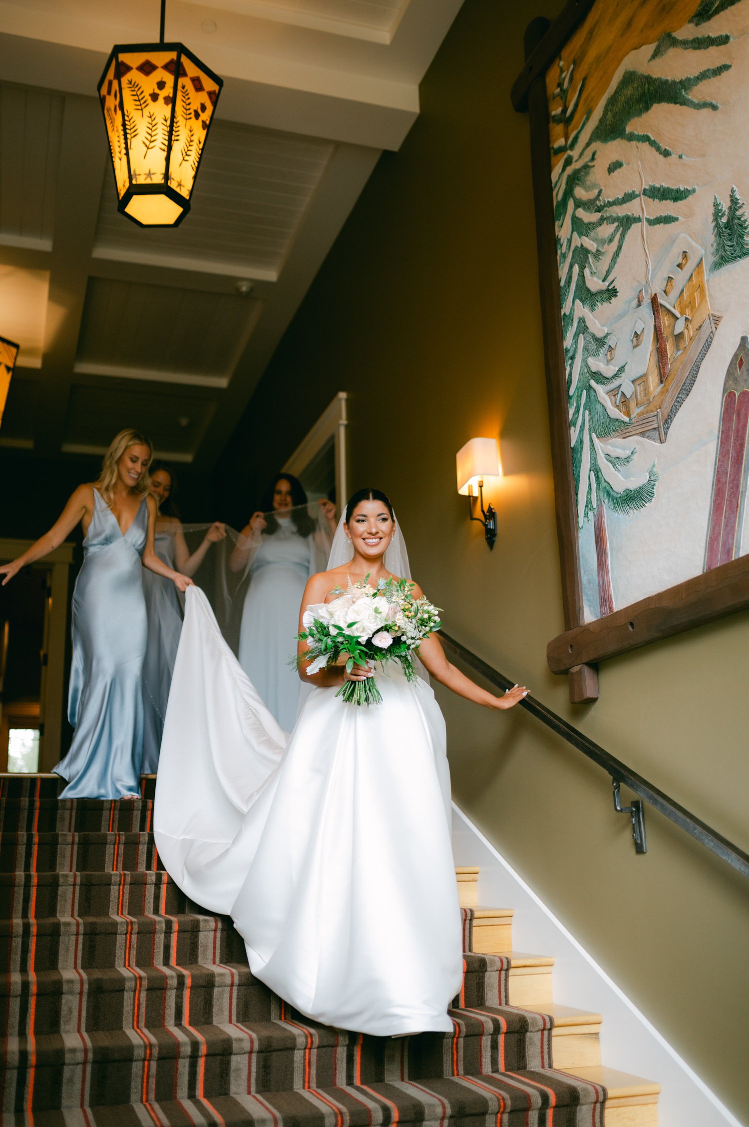 Martis Camp Wedding, photo of the bride with her bridesmaids walking down the stairs
