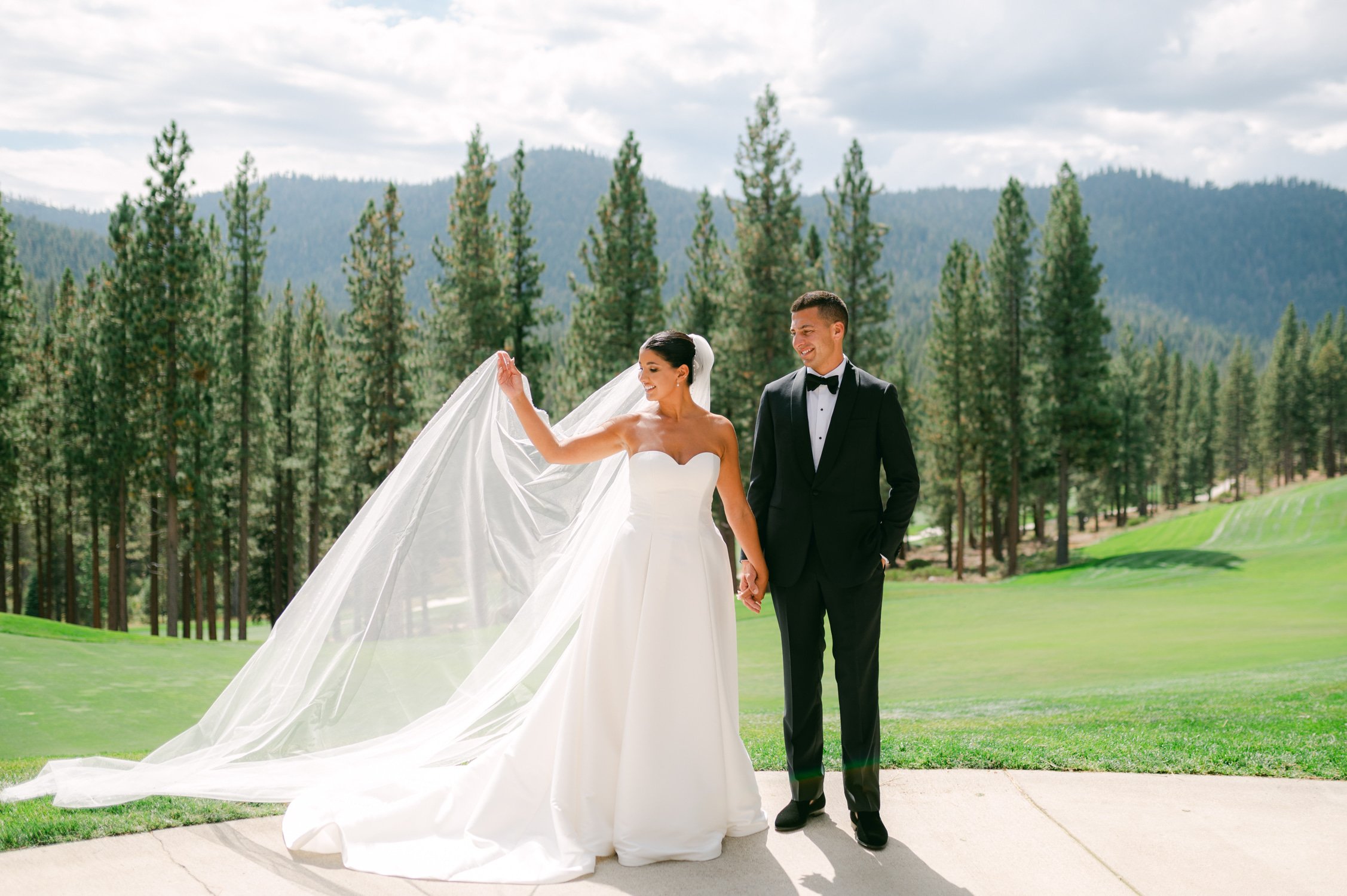 Martis Camp Wedding, photo of the couple against the tall trees, bride holding her veil