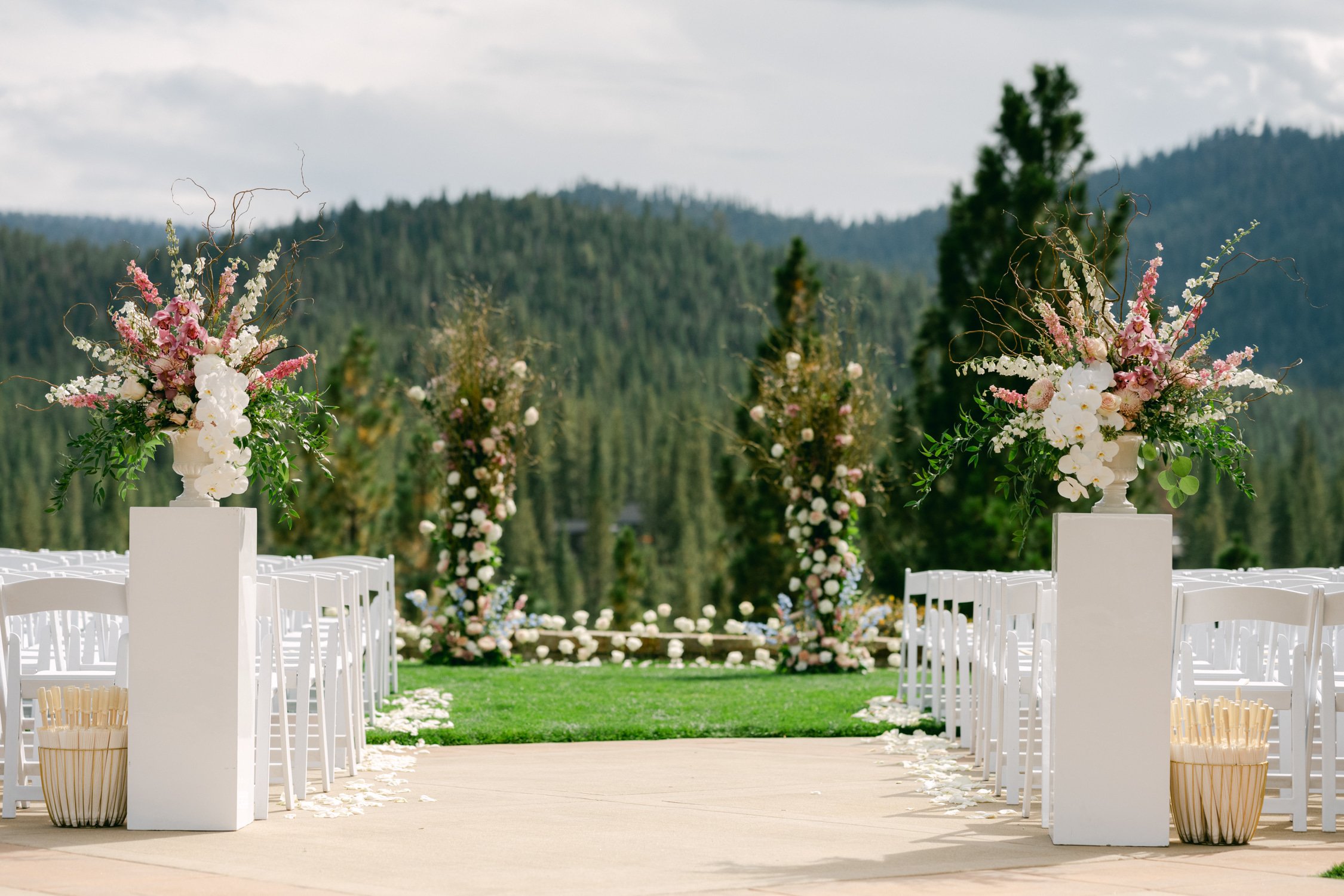 Martis Camp Wedding, photo of the outdoor wedding ceremony venue with simple flower setup by the mountains