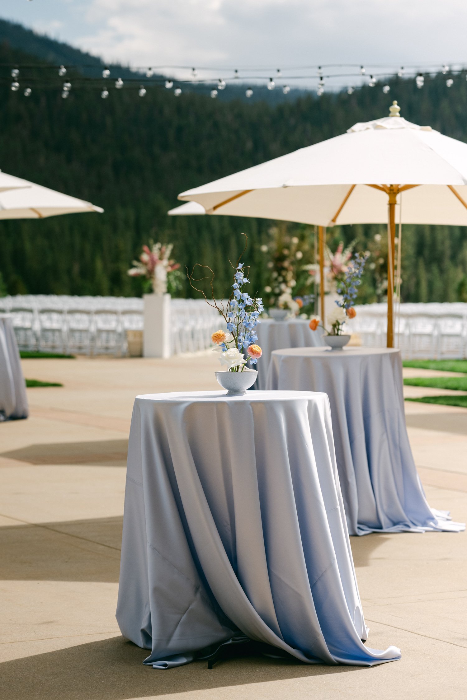 Martis Camp Wedding, photo of cocktails tables with blue tablecloth and simple blue centerpiece 