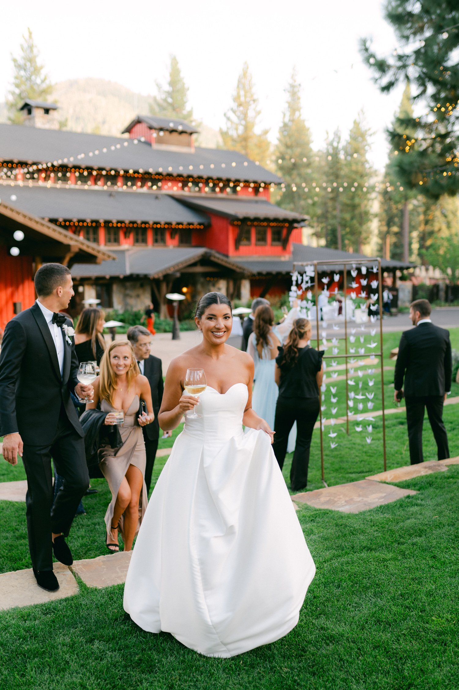 Martis Camp Wedding, photo of the bride holding a glass of wine walking to their evening reception