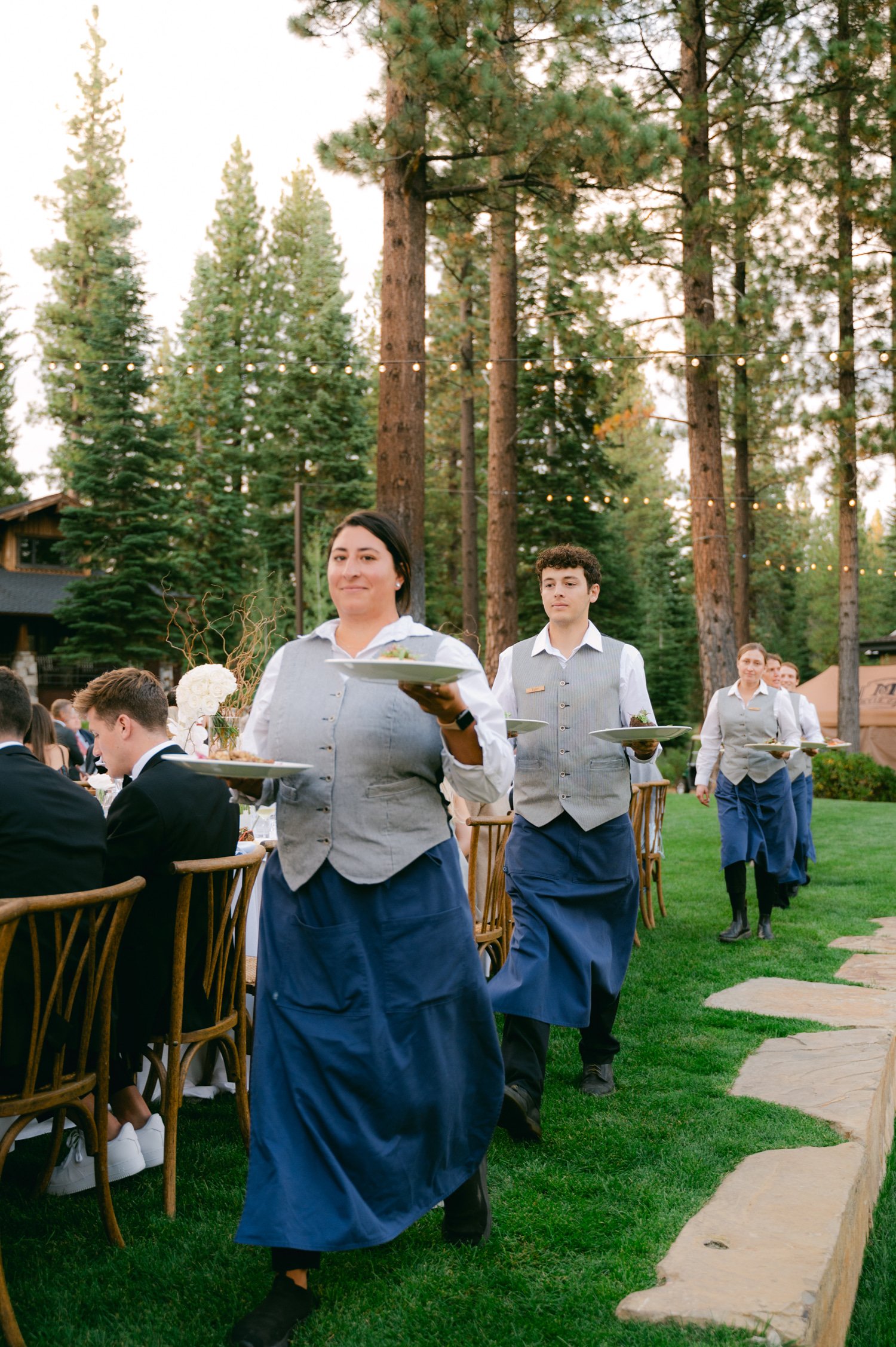 Martis Camp Wedding, photo of the servers serving the food during the outdoor evening reception