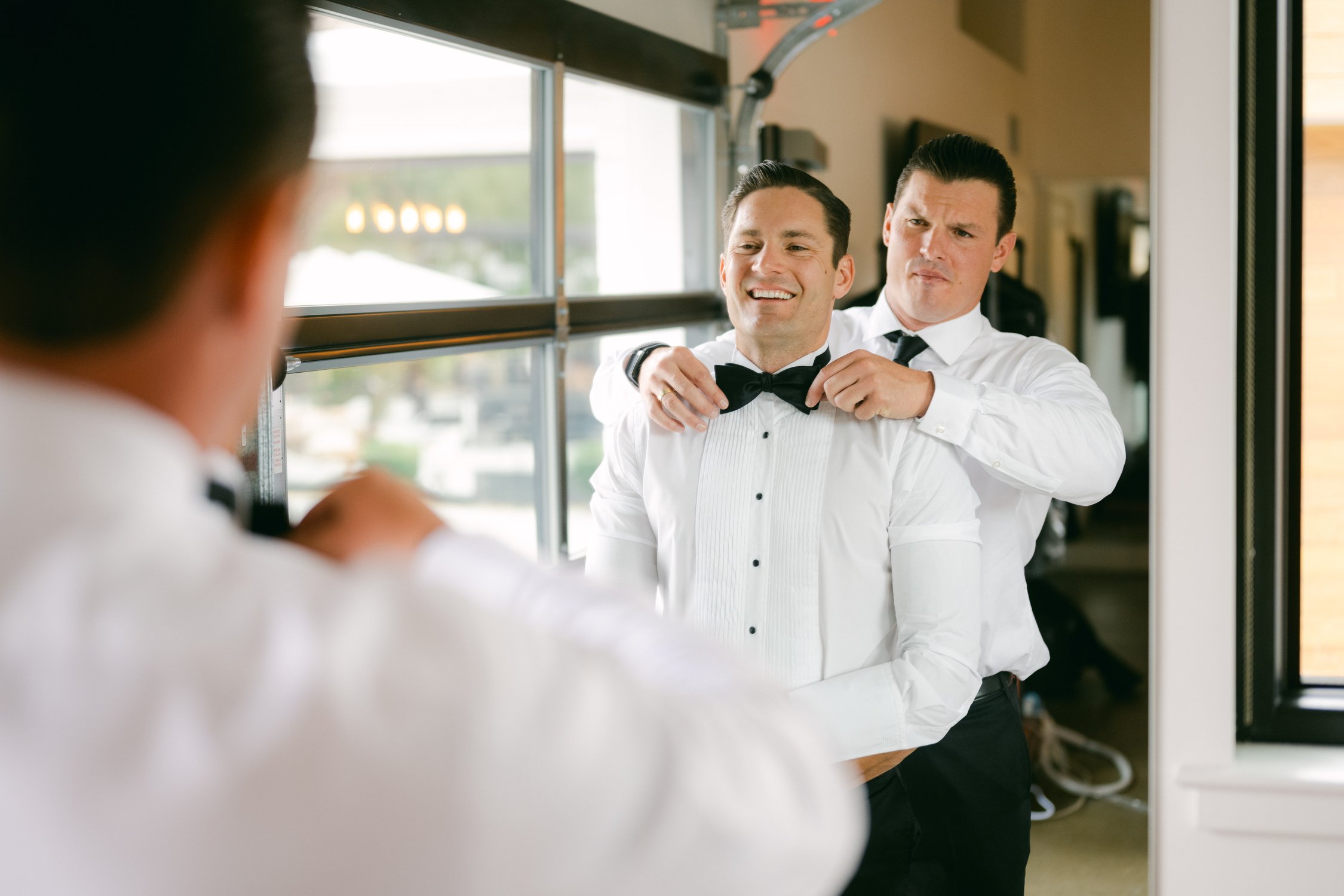 Elm Estate Wedding photos, photo of the best man fixing the groom’s bow tie for his wedding day