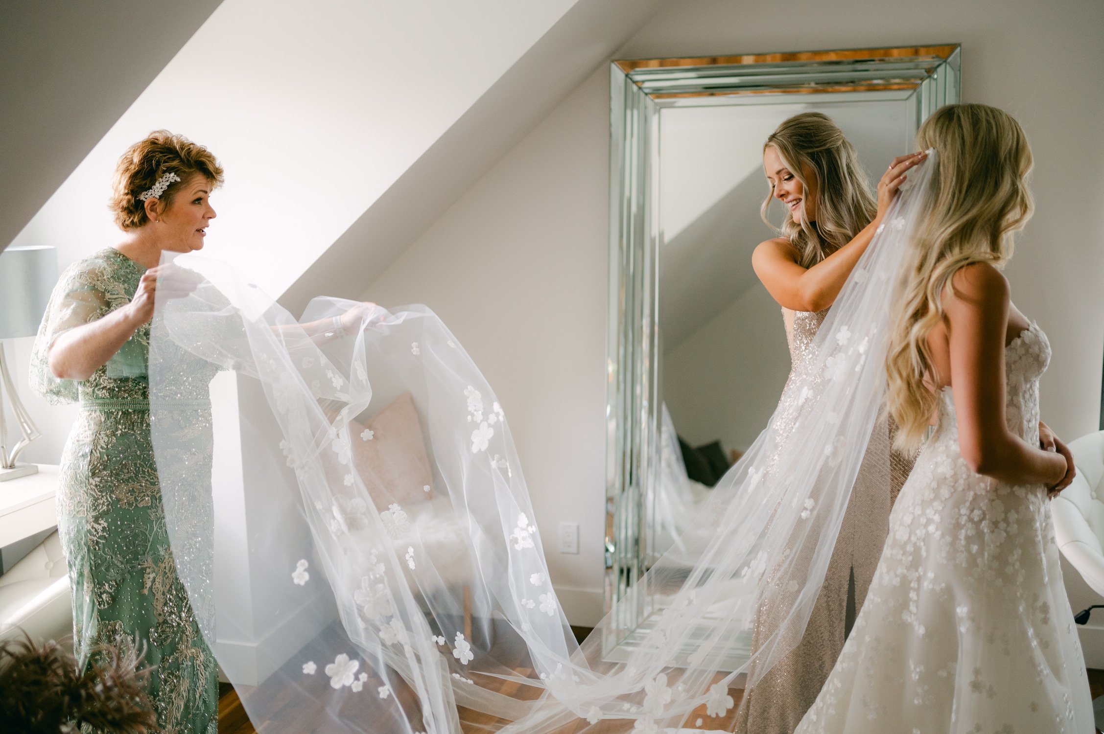 Elm Estate Wedding photos, photo of the maid of honor and the mother of the bride fixing the white flower-detailed veil of the bride