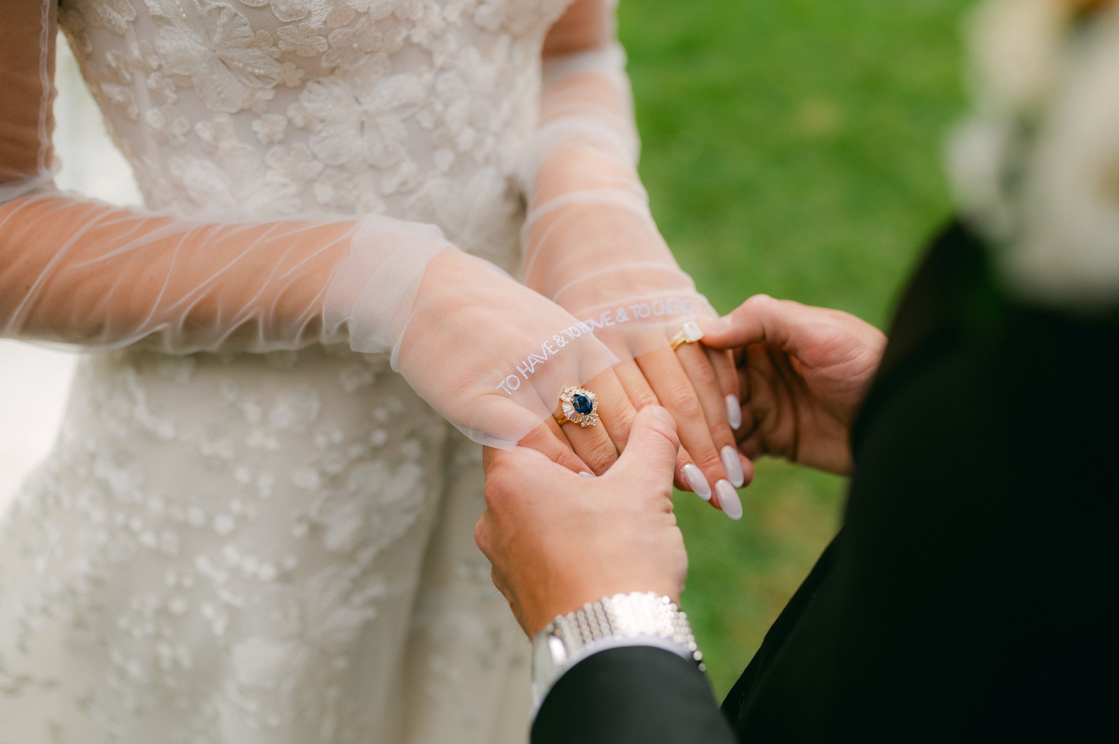 Elm Estate Wedding photos, photo of the bride and groom holding hands together, seeing all the elegant details of the bride with the customized sleeve, sapphire rings, and neutral wedding nails