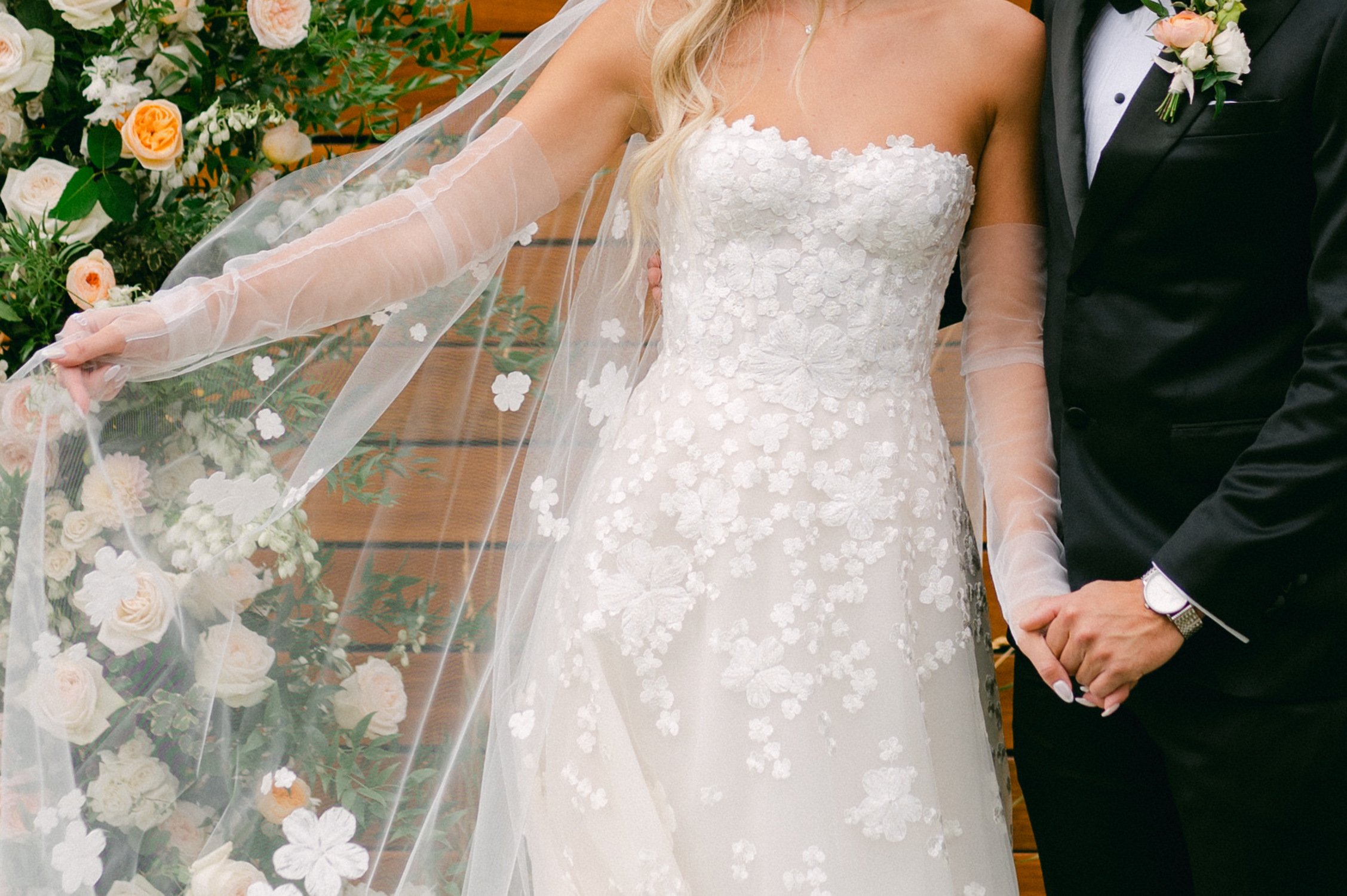 Elm Estate Wedding photos, photo of the bride's wedding dress with floral details and her veil with intricate floral designs and the groom in his black classic suit