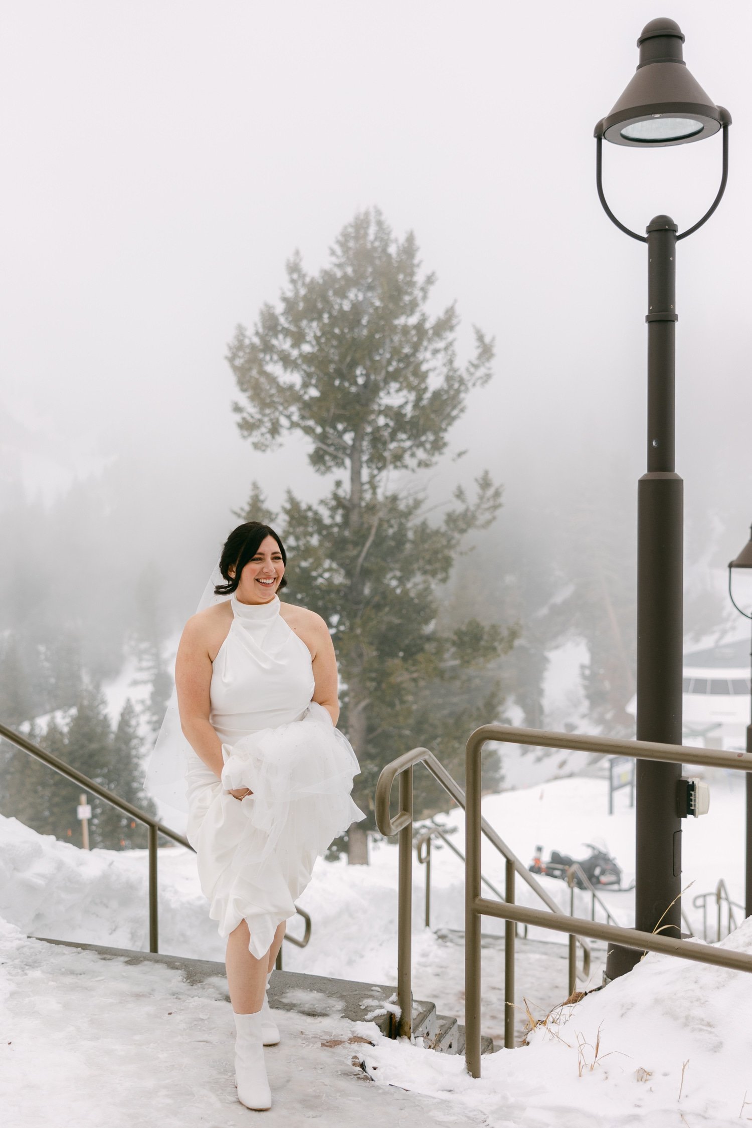 Sun Valley Roundhouse Wedding photos of the bride while holding on her dress and wearing her white boots arriving at the venue for their first look 