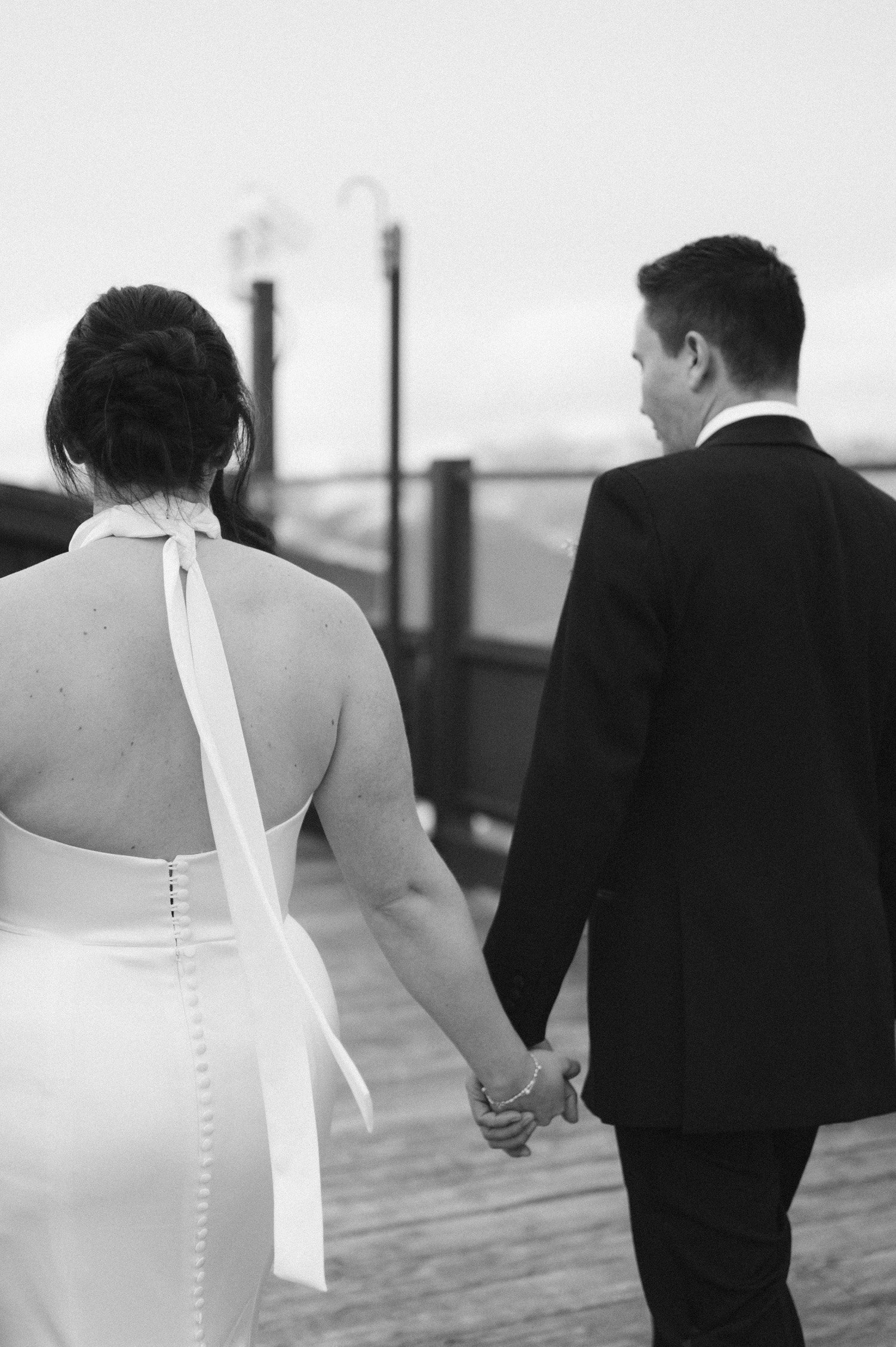 Sun Valley Roundhouse Wedding photo of the newlywed couple in black and white holding hands walking away