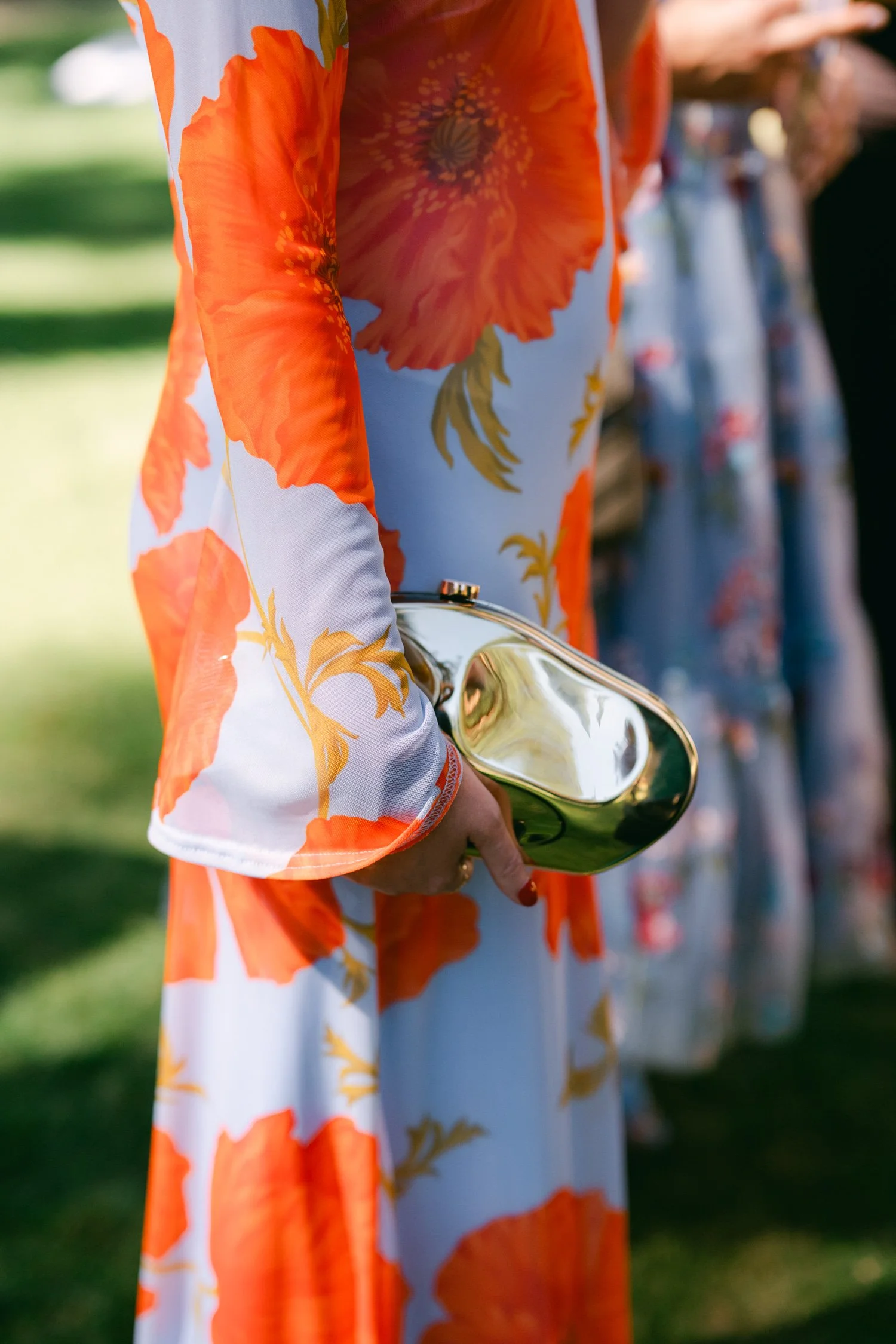 Valhalla wedding photo of a stylish guest in a chic dress with gold purse