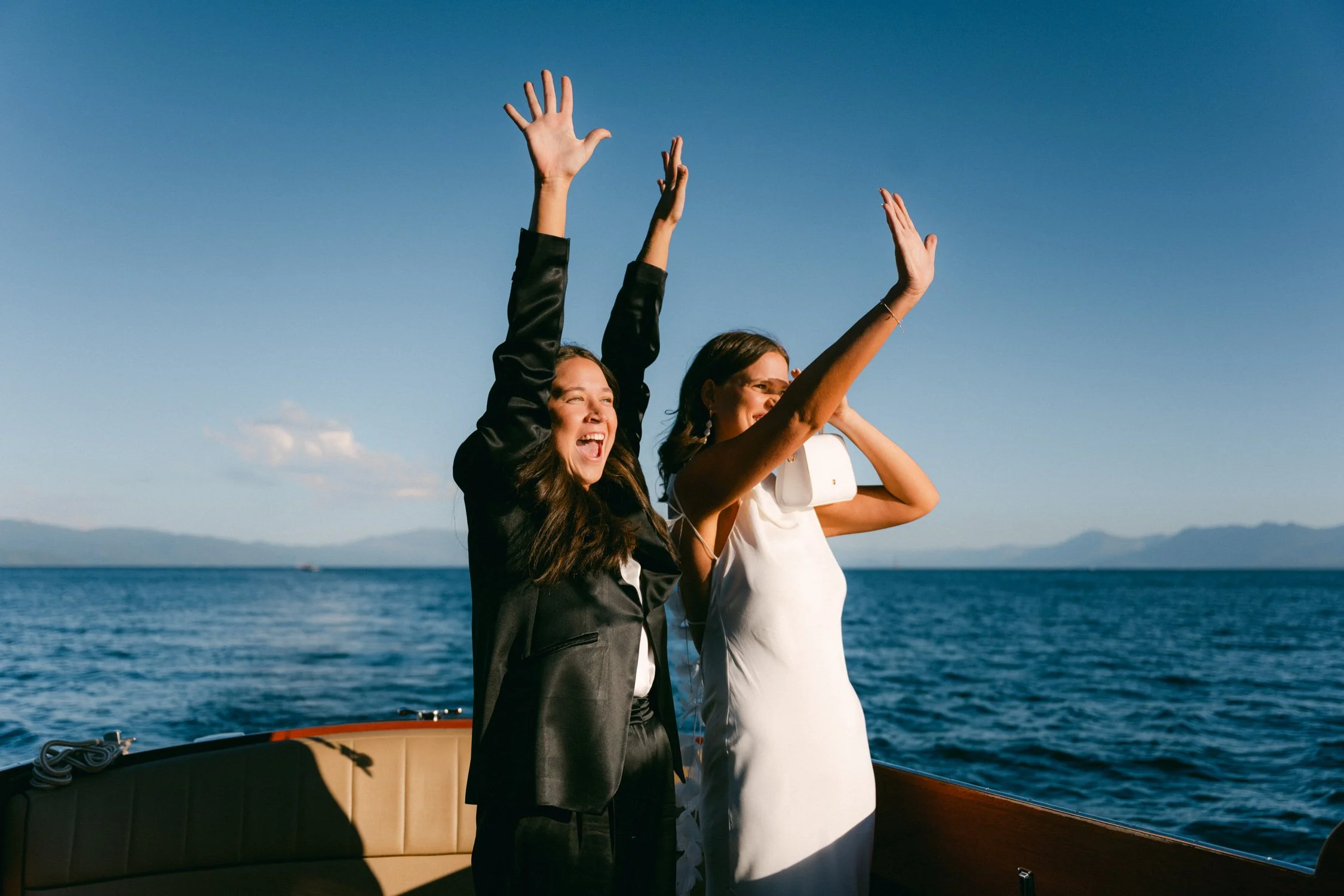 A Lake Tahoe summer wedding welcome party at garwoods, photo of the bride in a romantic backless wedding dress on a boat in Lake Tahoe
