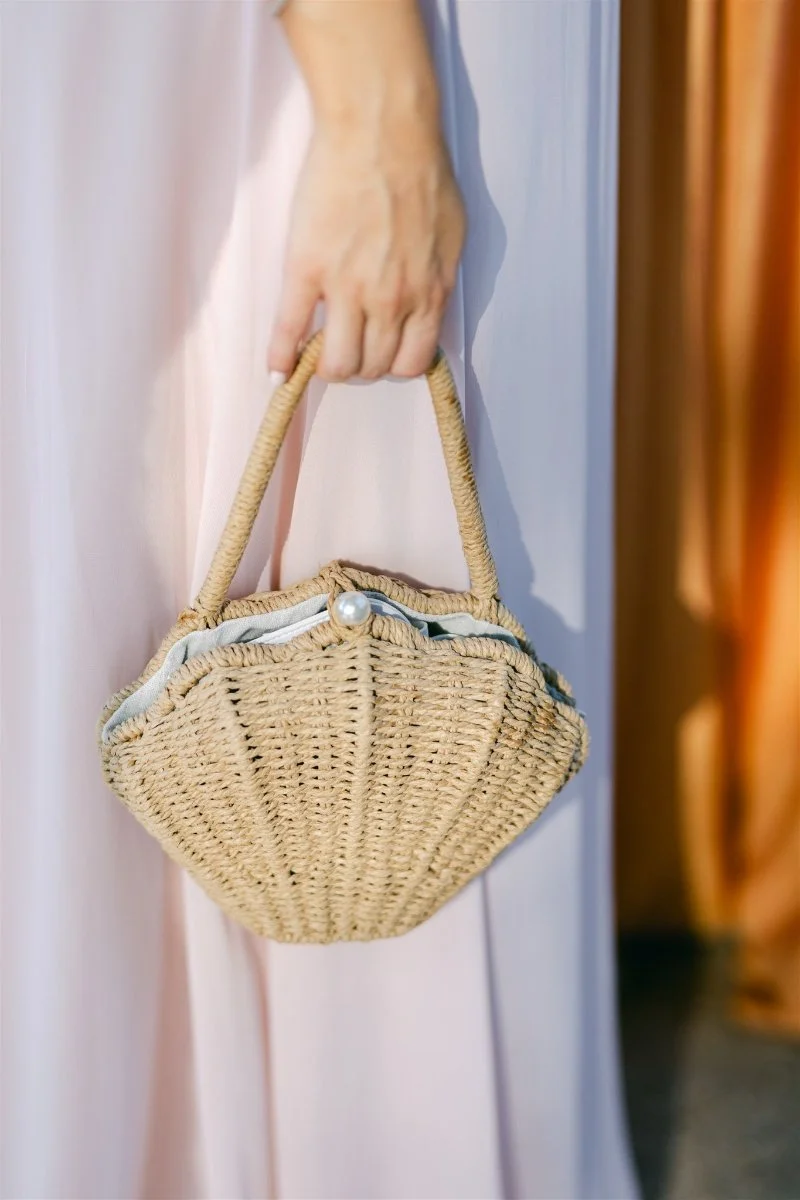 Beach Retreat &amp; Lodge at Tahoe wedding, photo of a seashell-shaped woven rattan handbag styled with a wedding guest outfit