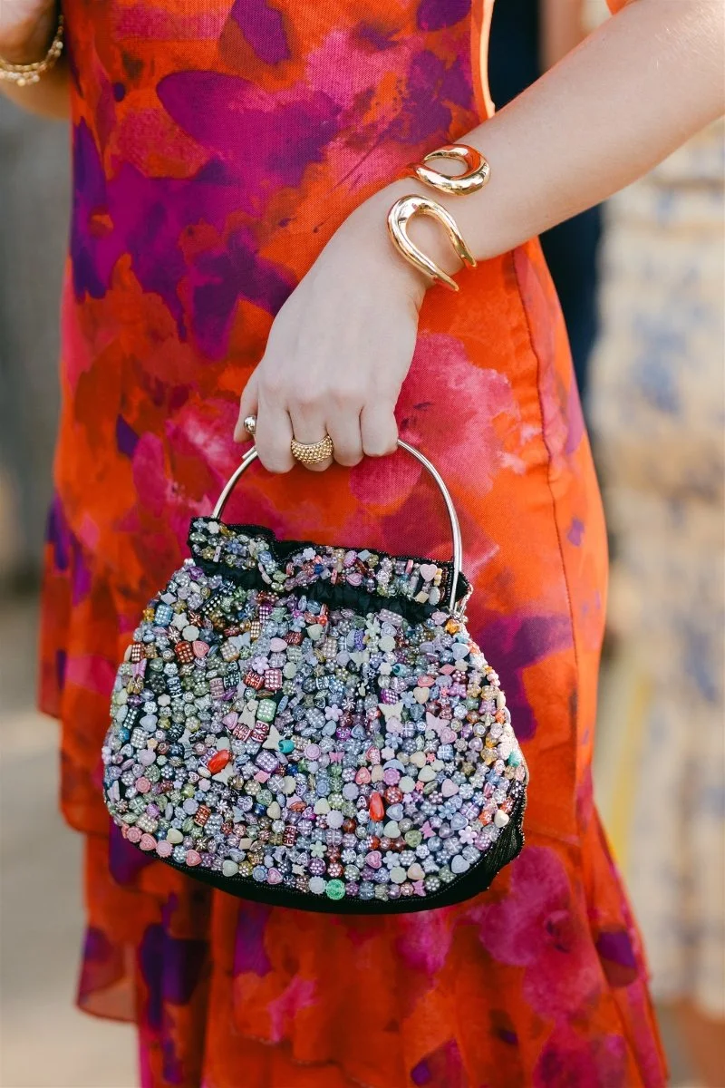 Beach Retreat &amp; Lodge at Tahoe wedding, photo of a wedding guest wearing a vibrant dress paired with a beaded clutch