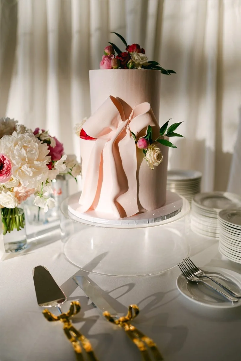 Beach Retreat &amp; Lodge at Tahoe wedding, photo of the pink wedding cake styled with bow accents and pink and white florals