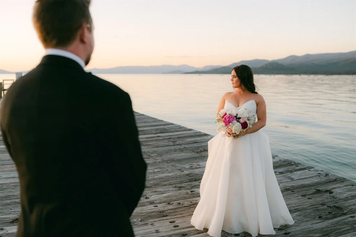 Beach Retreat &amp; Lodge at Tahoe wedding, photo of the bride and groom standing by the shoreline with vibrant florals and a strapless gown