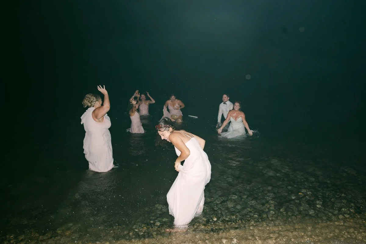 Beach Retreat &amp; Lodge at Tahoe wedding, photo of the couple and their wedding party jumping into the ocean at night in their wedding attire