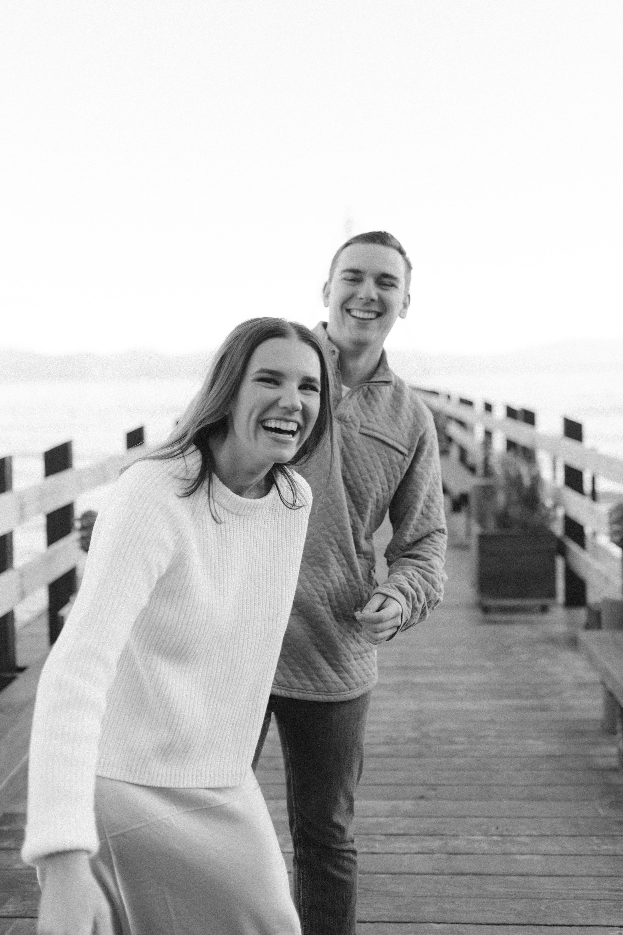 Lake Tahoe Engagement session, photo of the couple sharing a candid and joyful moment on a wooden boardwalk