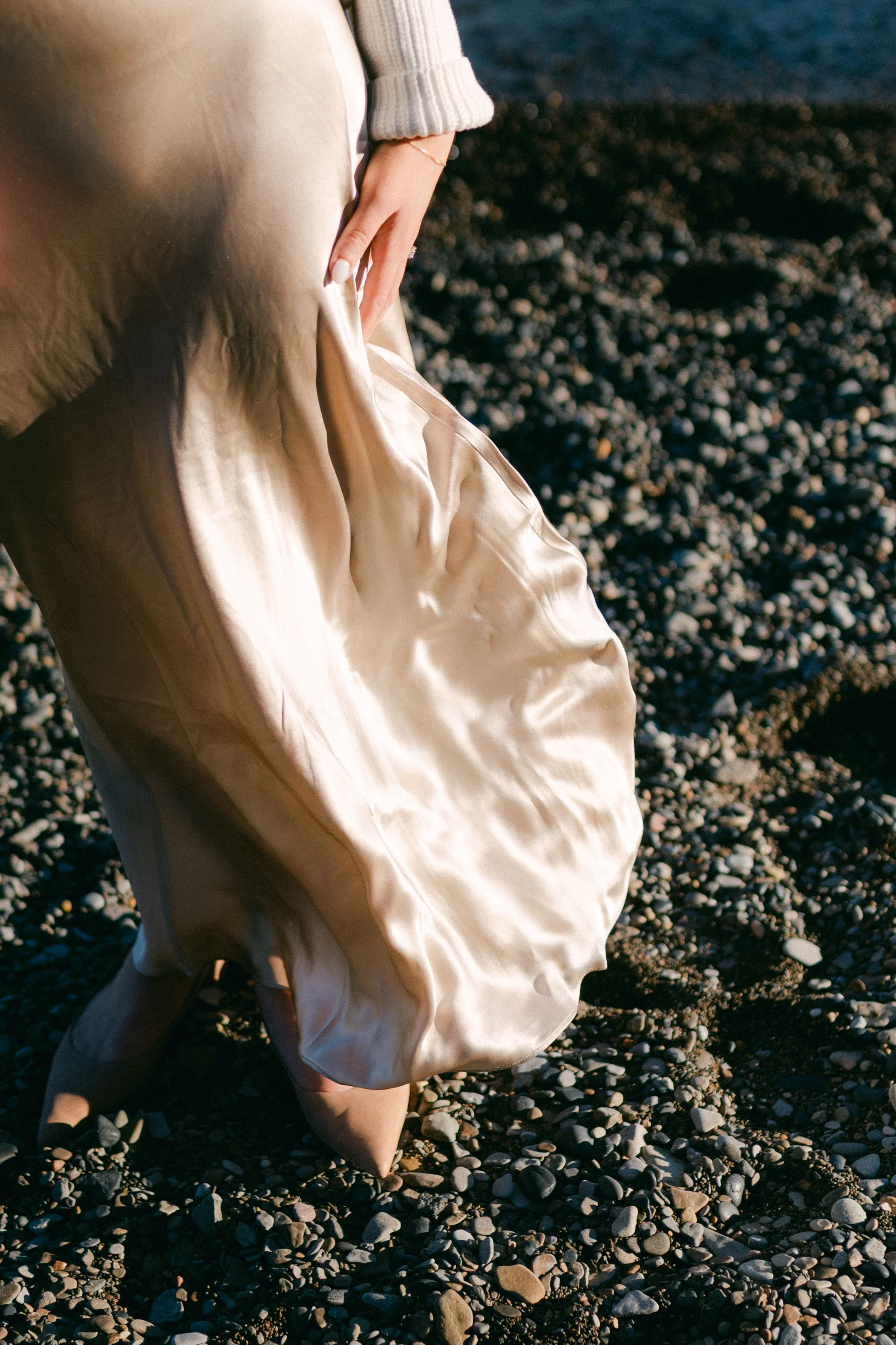Lake Tahoe Engagement session, photo of the bride’s champagne satin skirt flowing softly as she stands by the lake