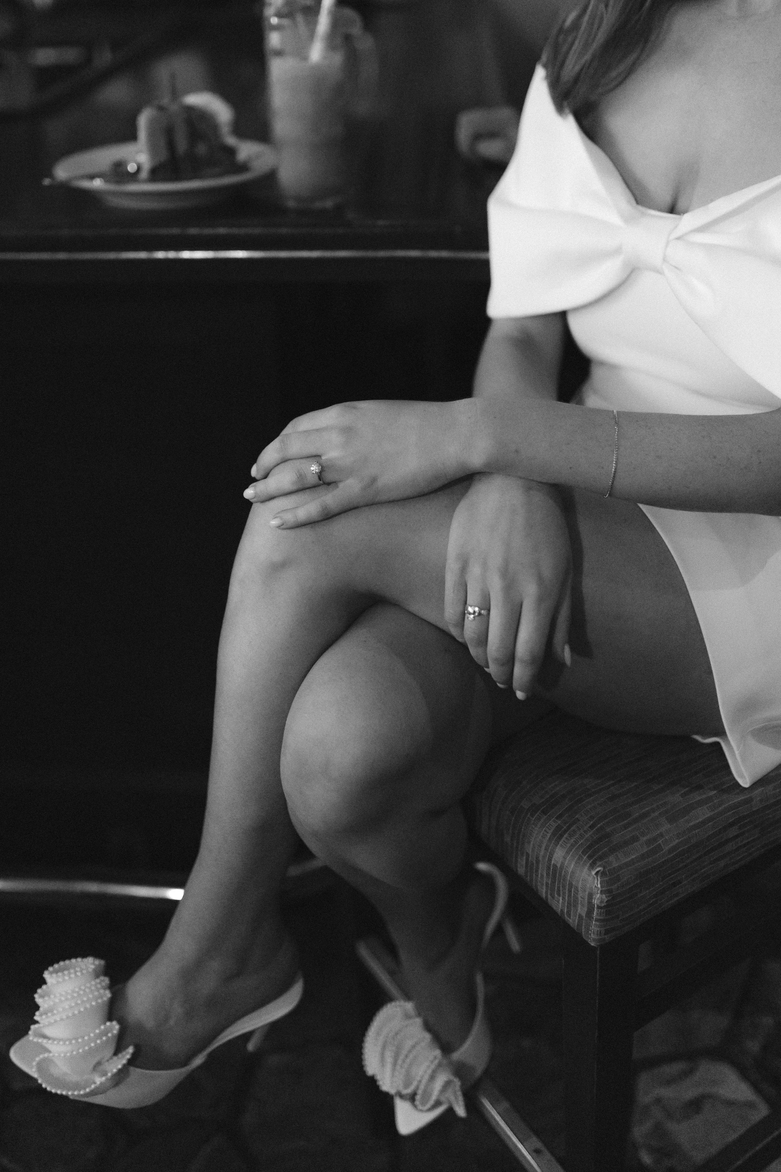 Lake Tahoe Engagement session, photo of the bride wearing a white mini dress with a bow neckline and matching embellished heels