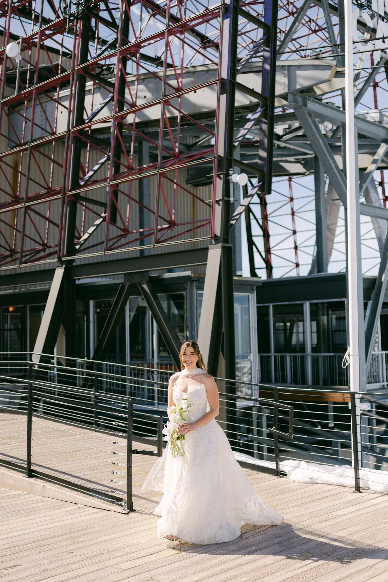 High Camp Ceremony, photo of the bride holding a white floral bouquet walking on a wooden deck