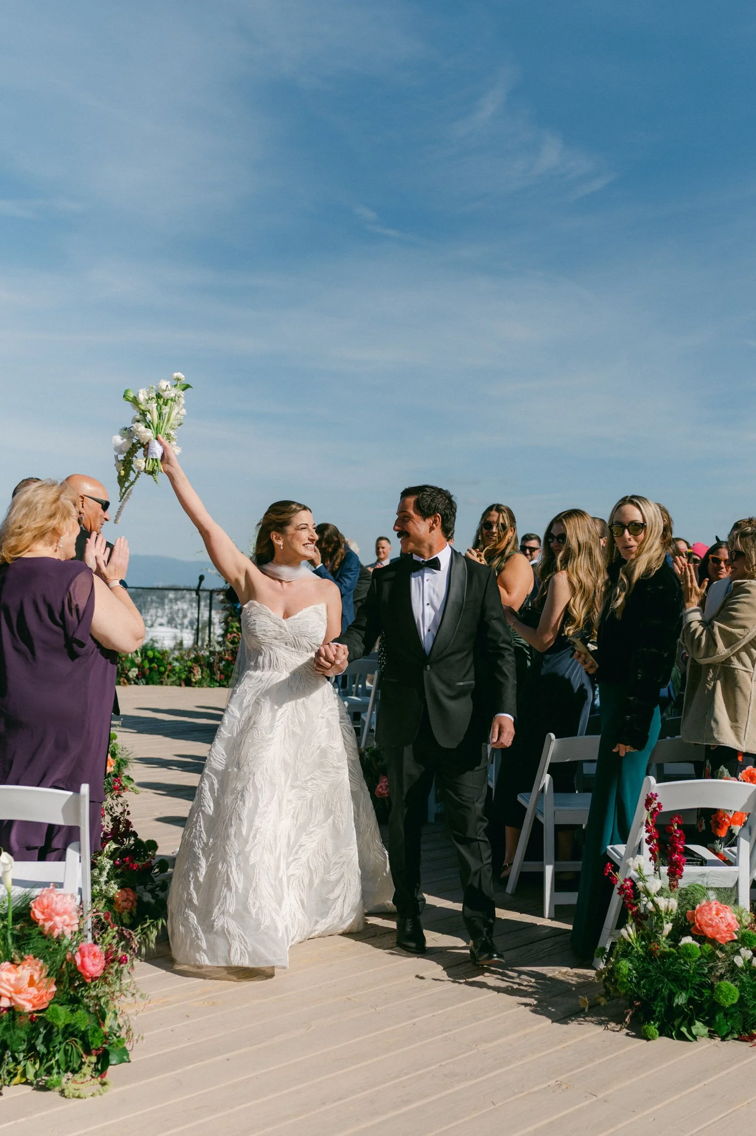 High Camp Ceremony, photo of the newly married couple walking down the aisle together, beaming with joy and celebration.