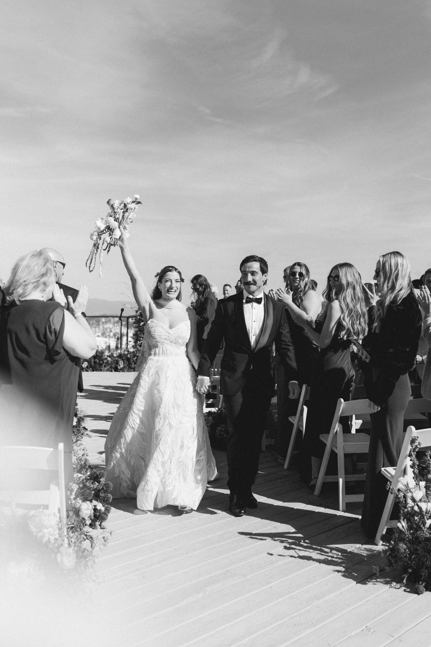 High Camp Ceremony, photo of joyous wedding ceremony moment where the newlyweds are walking down the aisle, celebrated by their guests.