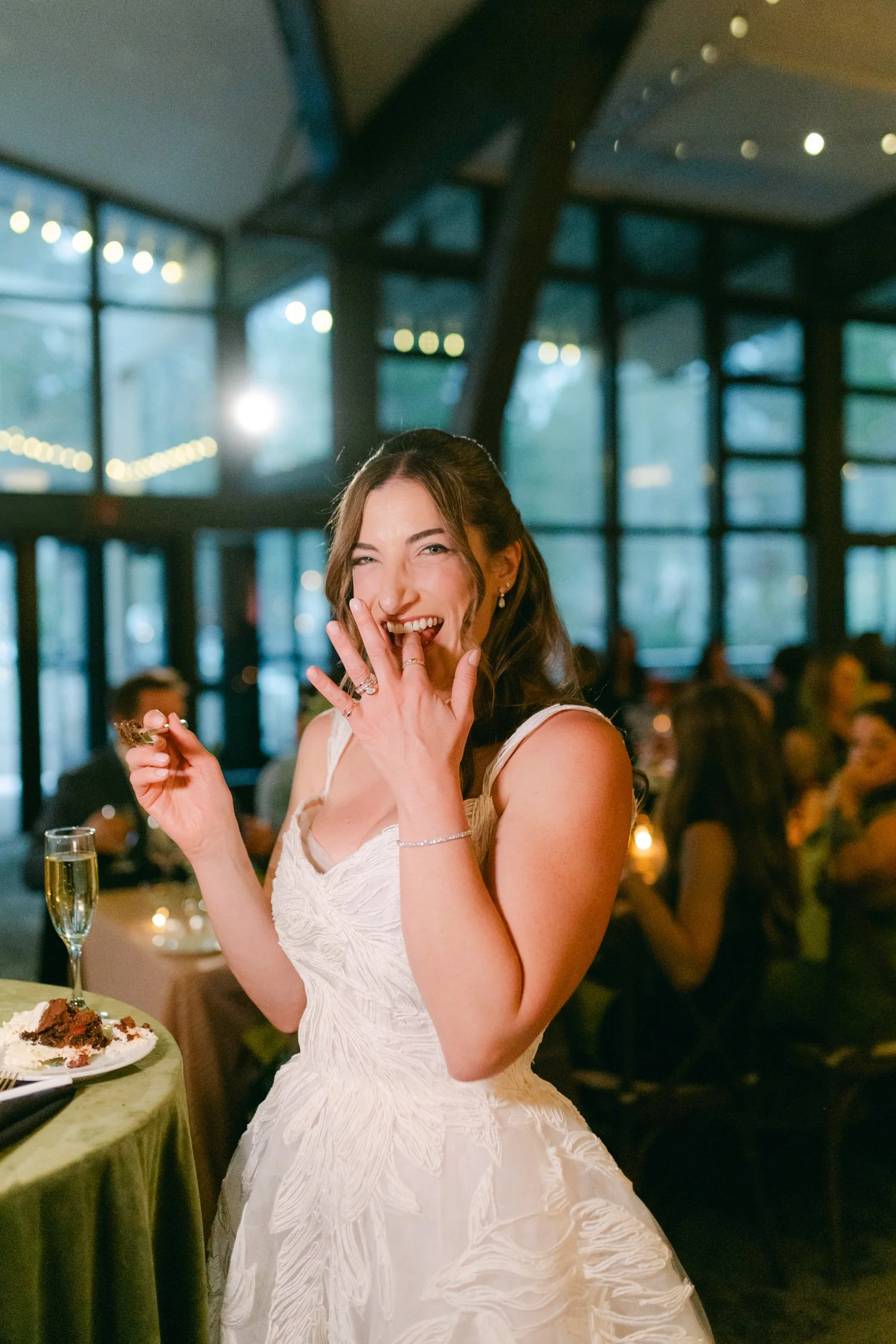 Palisades wedding venue, photo of the bride enjoying her wedding cake wearing a bridal gown with a white, textured lace design.