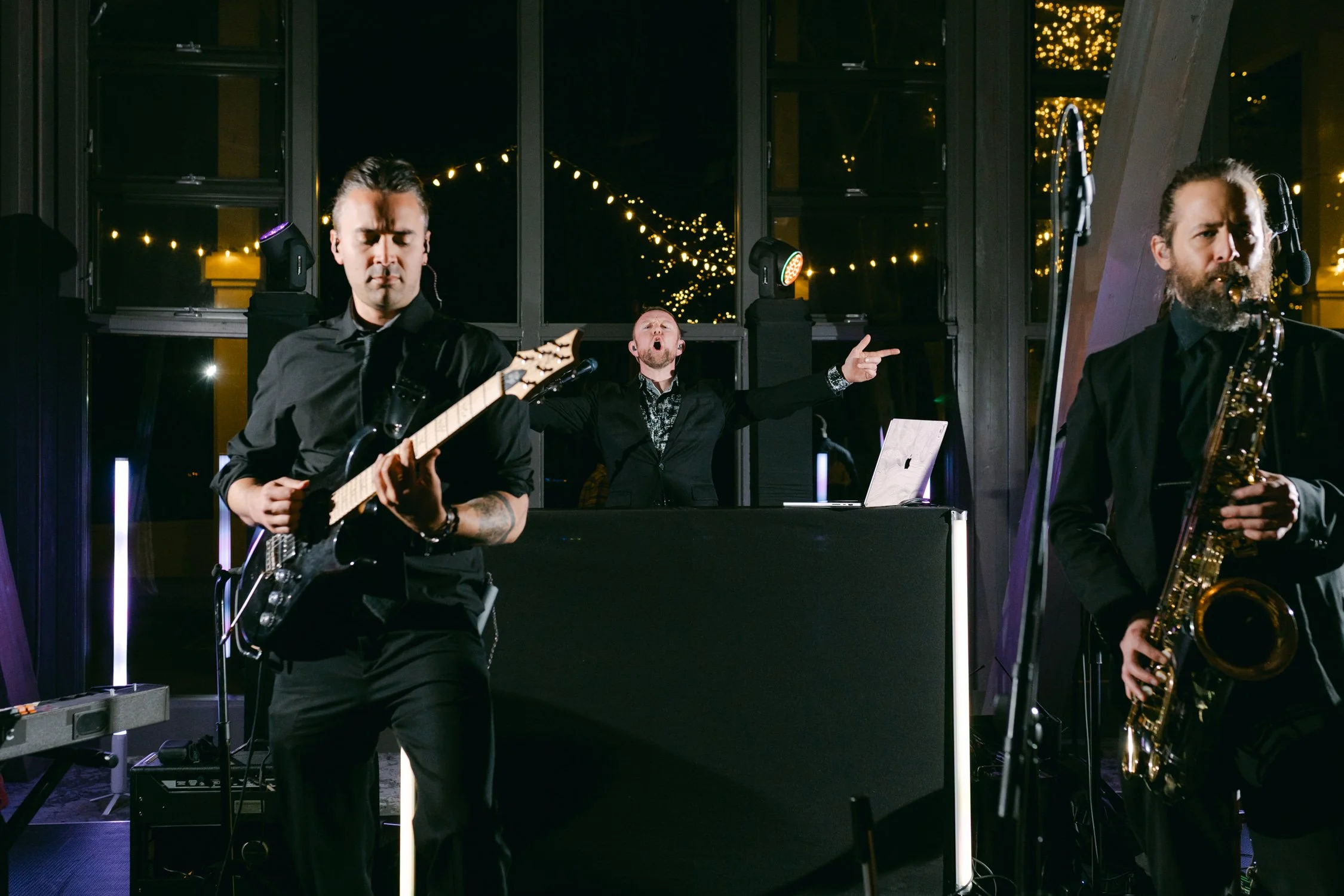 Palisades wedding venue, photo of live musical performance featuring a guitarist and a saxophonist playing in front of a DJ setup.