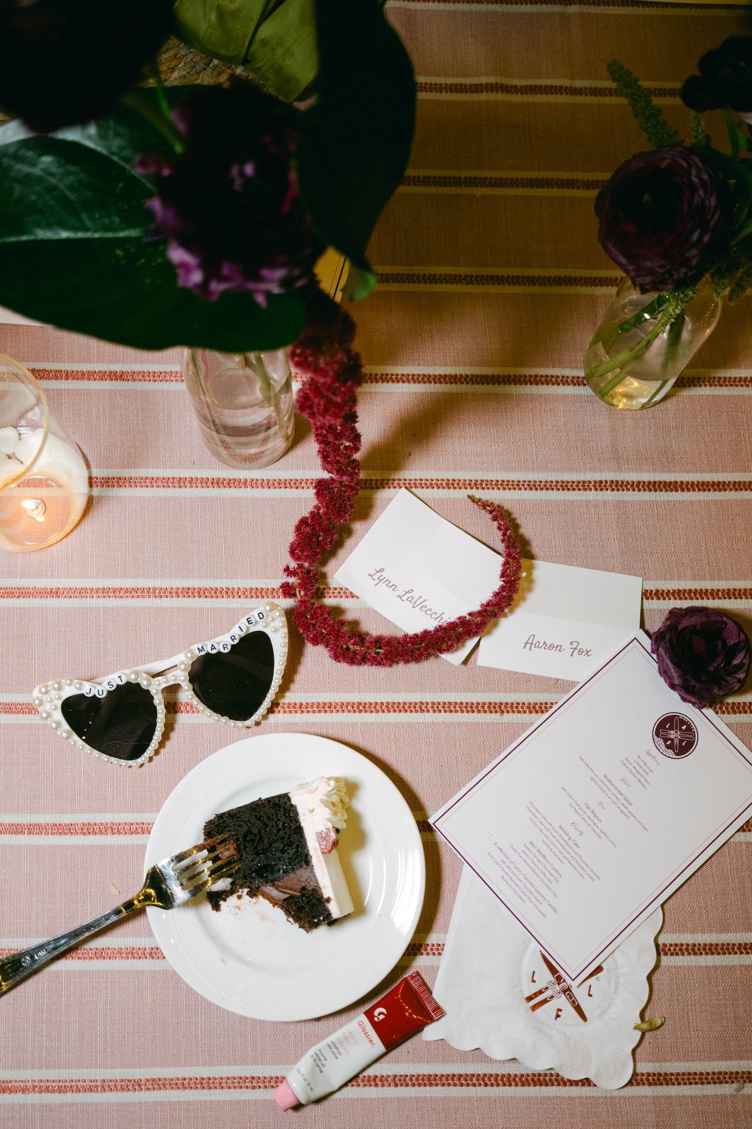 Palisades wedding venue, photo of festive wedding reception table setting, featuring a slice of chocolate cake and fun accessories.