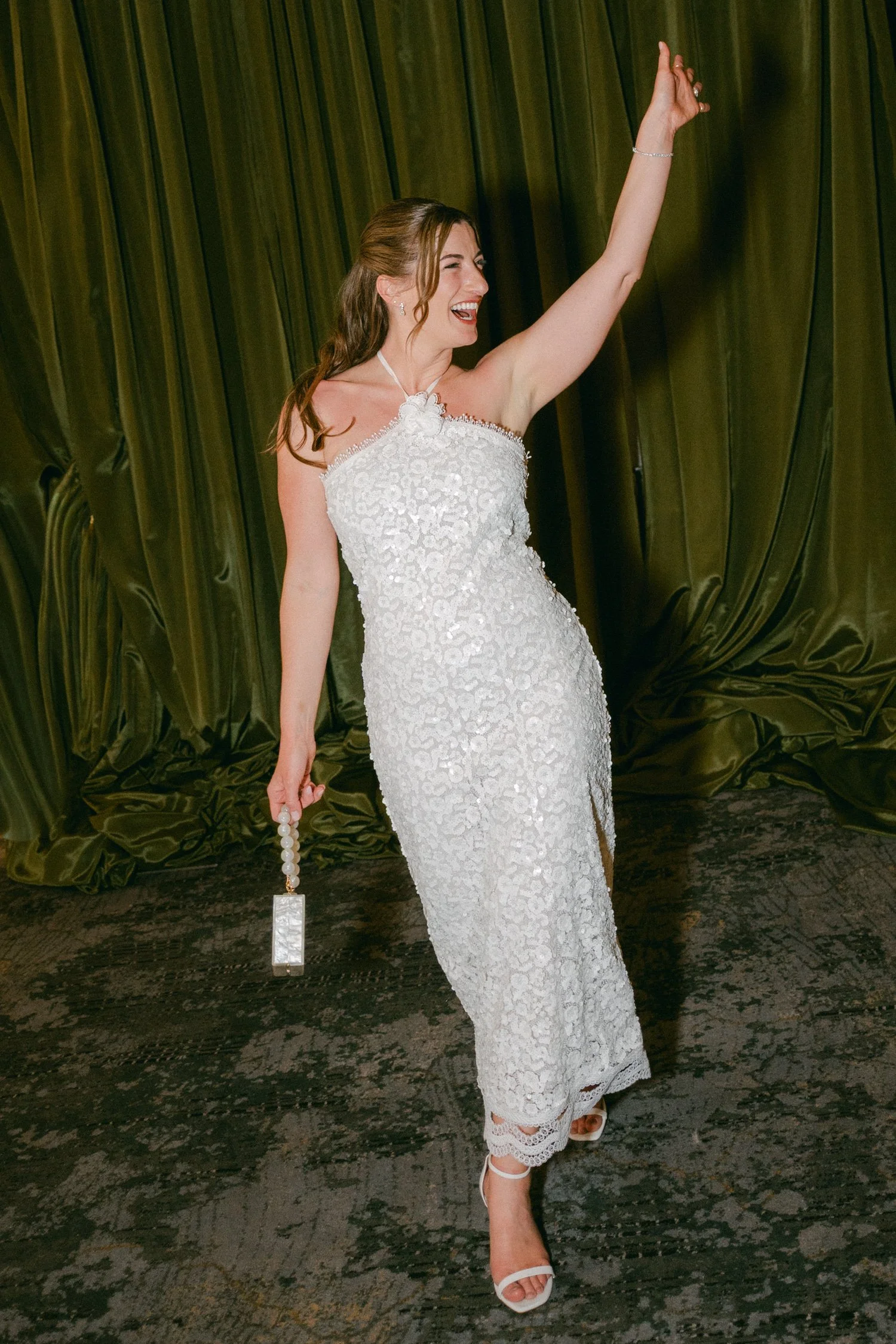 Palisades wedding venue, photo of the bride in her afterparty dress featuring all-over sequin embellishments and a halter neckline with a central floral details