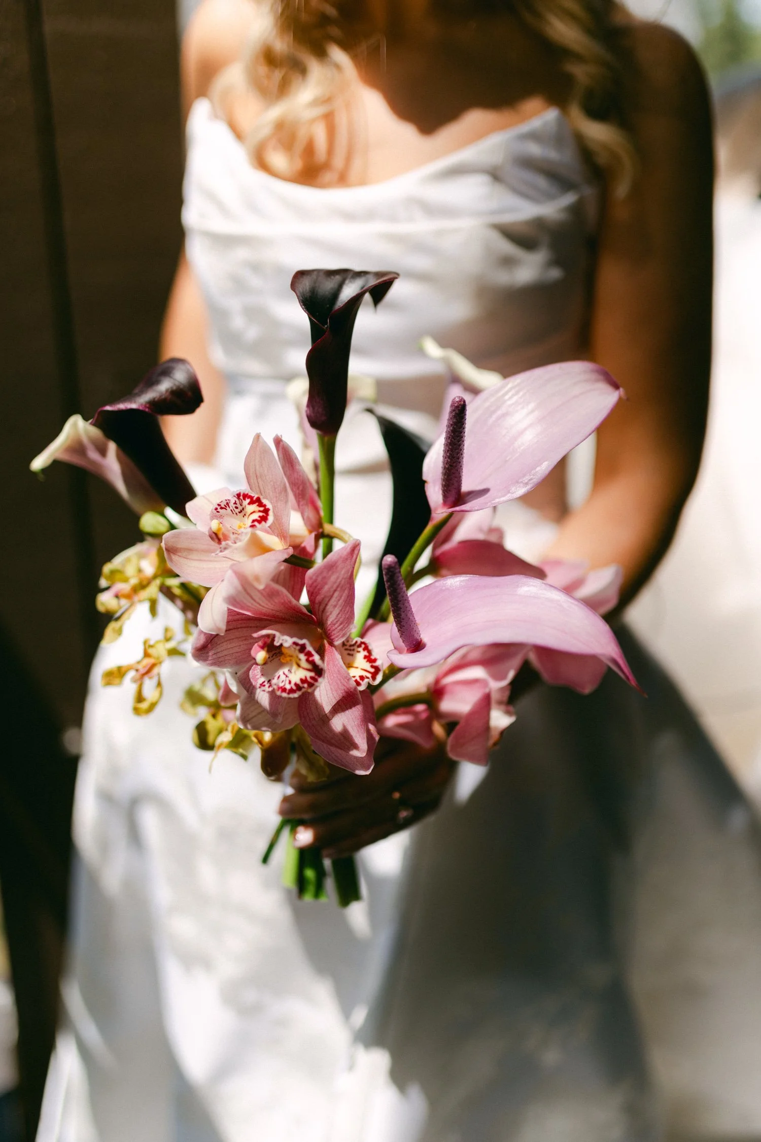 Edgewood maximalist wedding, photo of wedding bouquet featuring deep purple Calla Lilies and vibrant pink orchids, highlighting a modern and unconventional arrangement