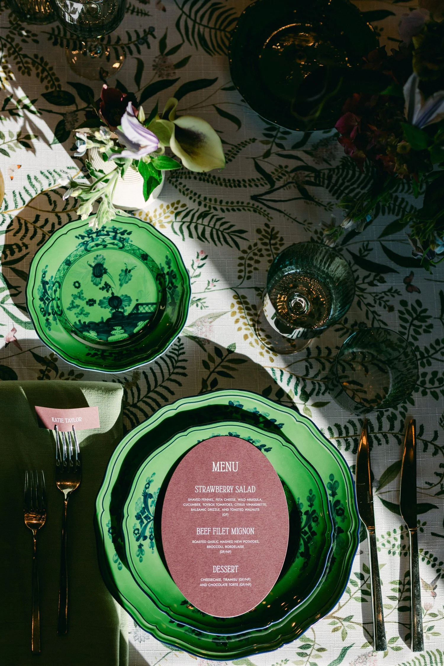 Edgewood maximalist wedding, photo of vibrant tablescape inspired by Ginori 1735 Oriente Italiano dinnerware in the Malachite green colorway, set atop a patterned botanical tablecloth