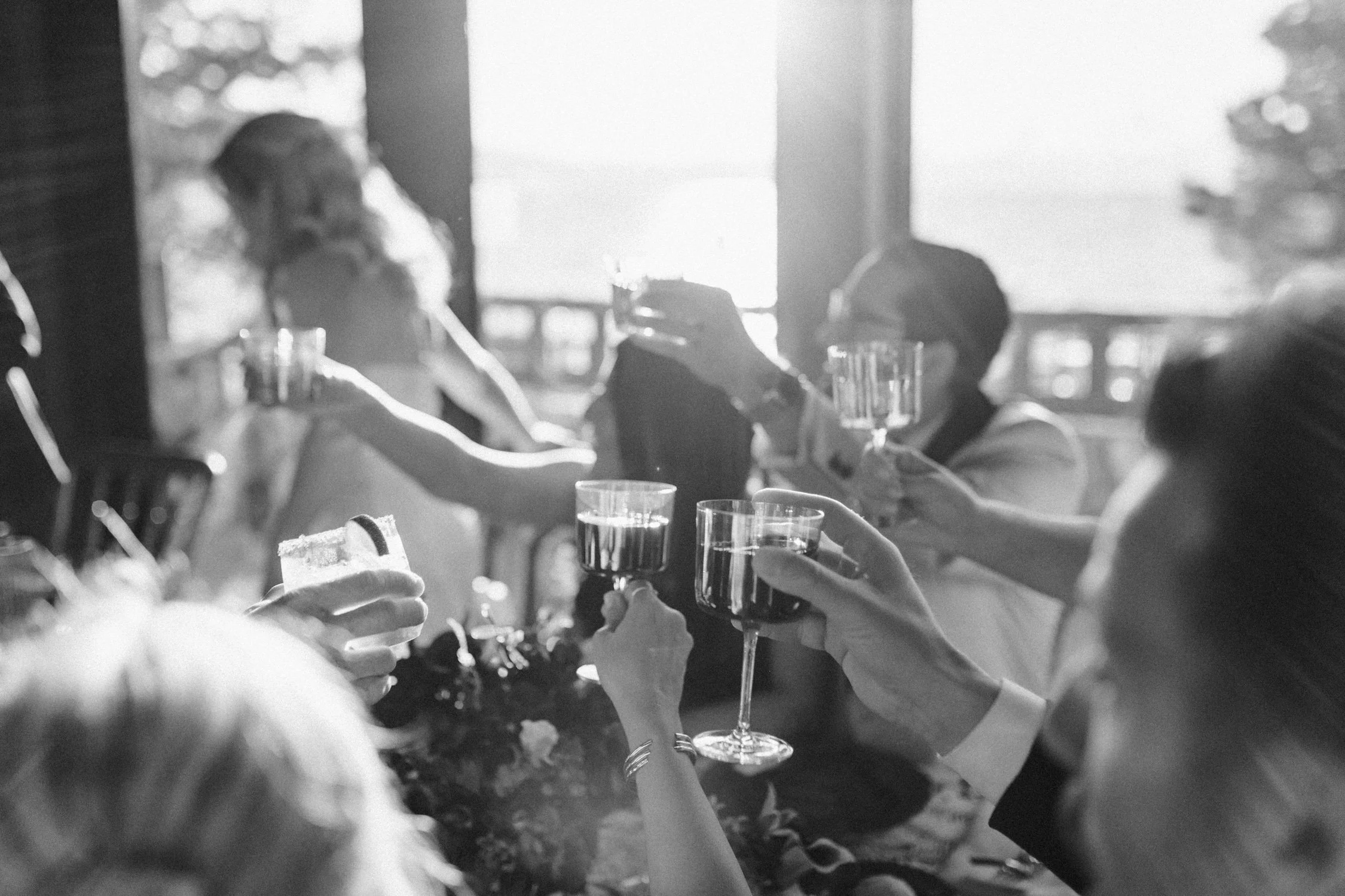Edgewood maximalist wedding, photo of a candid wedding reception moment featuring guests raising glasses for a toast