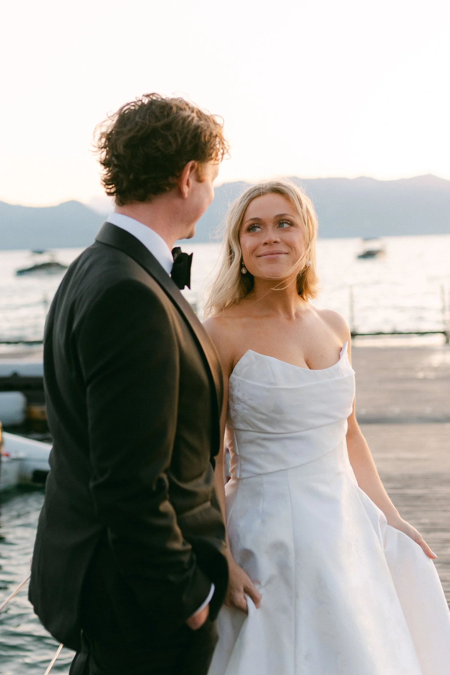 Edgewood maximalist wedding, photo of the bride and groom walking with the bride wearing a a strapless sweetheart wedding dress featuring a structured bodice and a full skirt