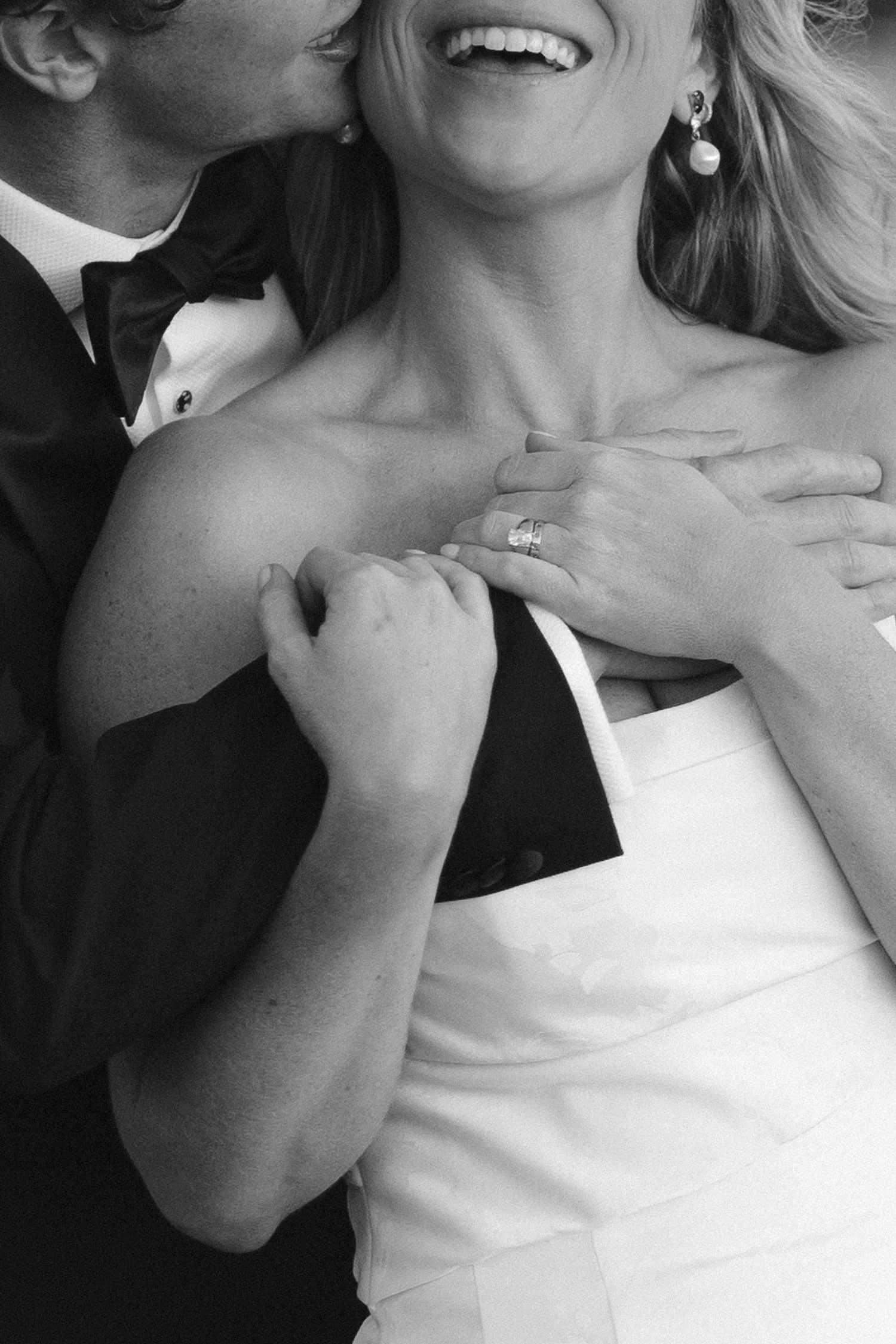 Edgewood maximalist wedding, photo of the newlyweds sharing a joyful moment at a wedding in a black and white portrait.