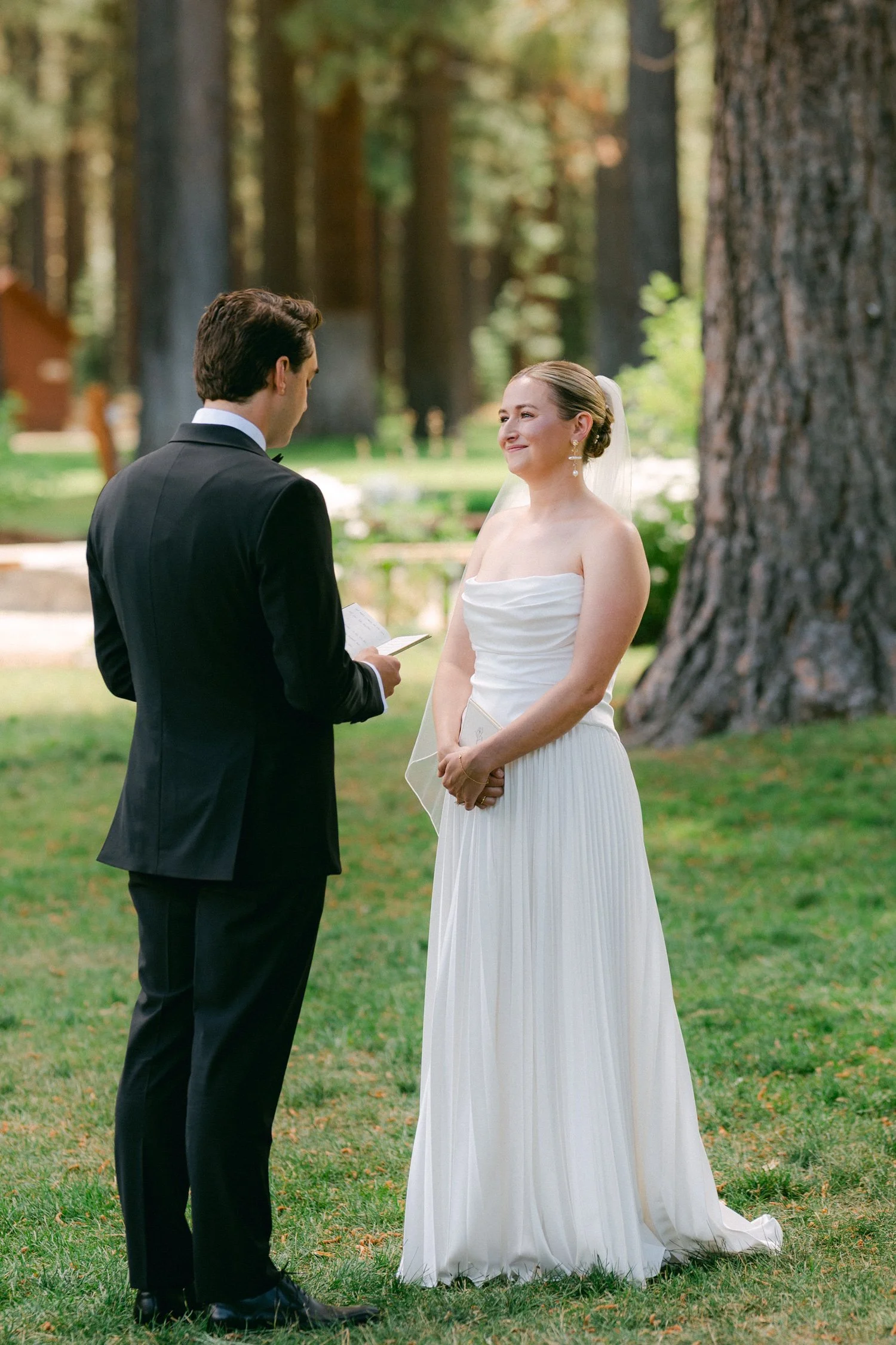 Lake Tahoe 4-H Camp wedding photos, photo of the bride and groom during their first look in an outdoor setting surrounded by tall trees.